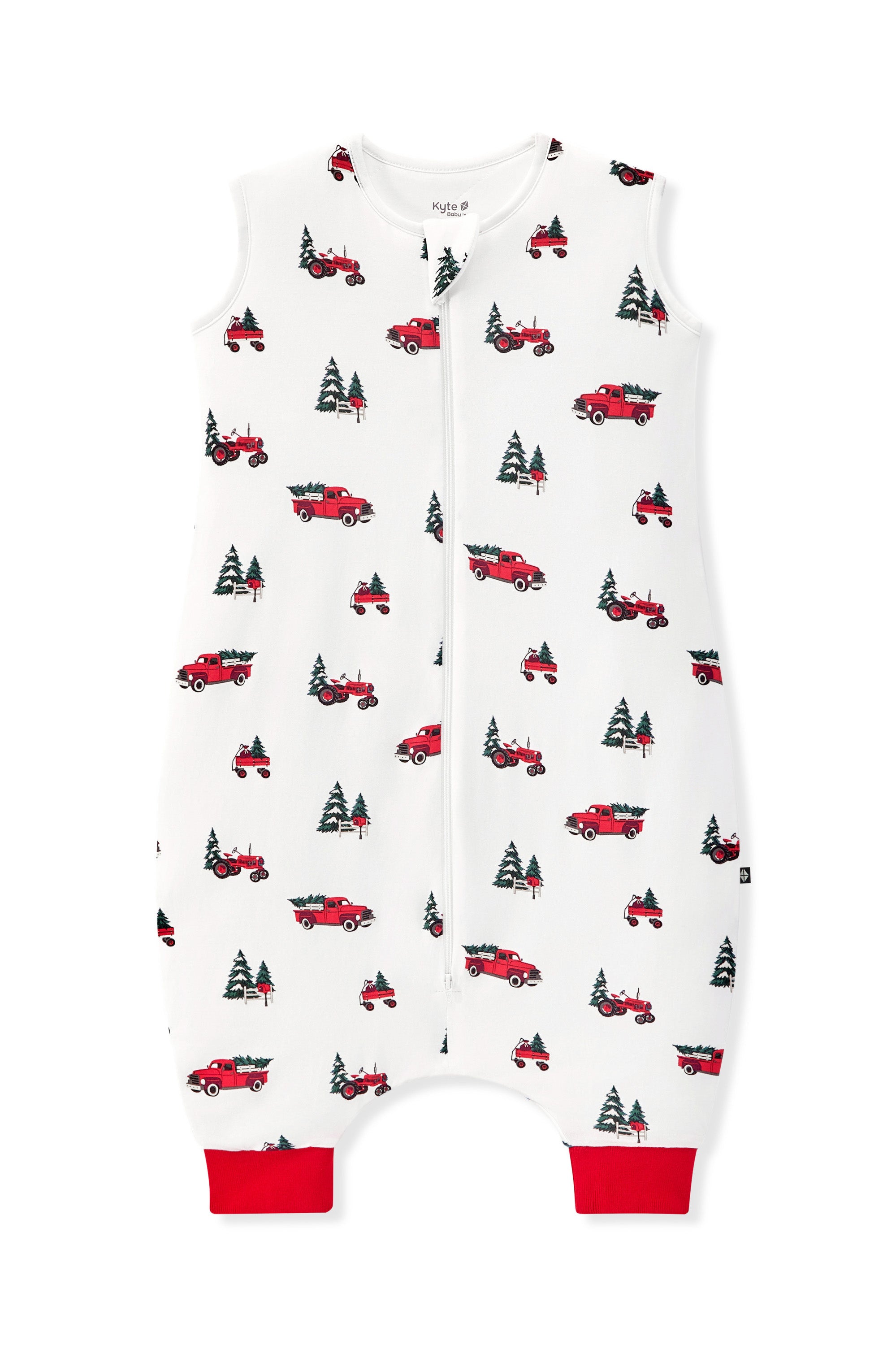 A white baby sleep bag walker with a red and green holiday print of trucks and pine trees, featuring a front zipper and red trim at the crotch and leg cuffs.