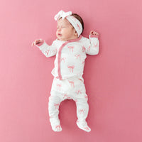 Newborn wearing Lulla Babys take me home set in bow print