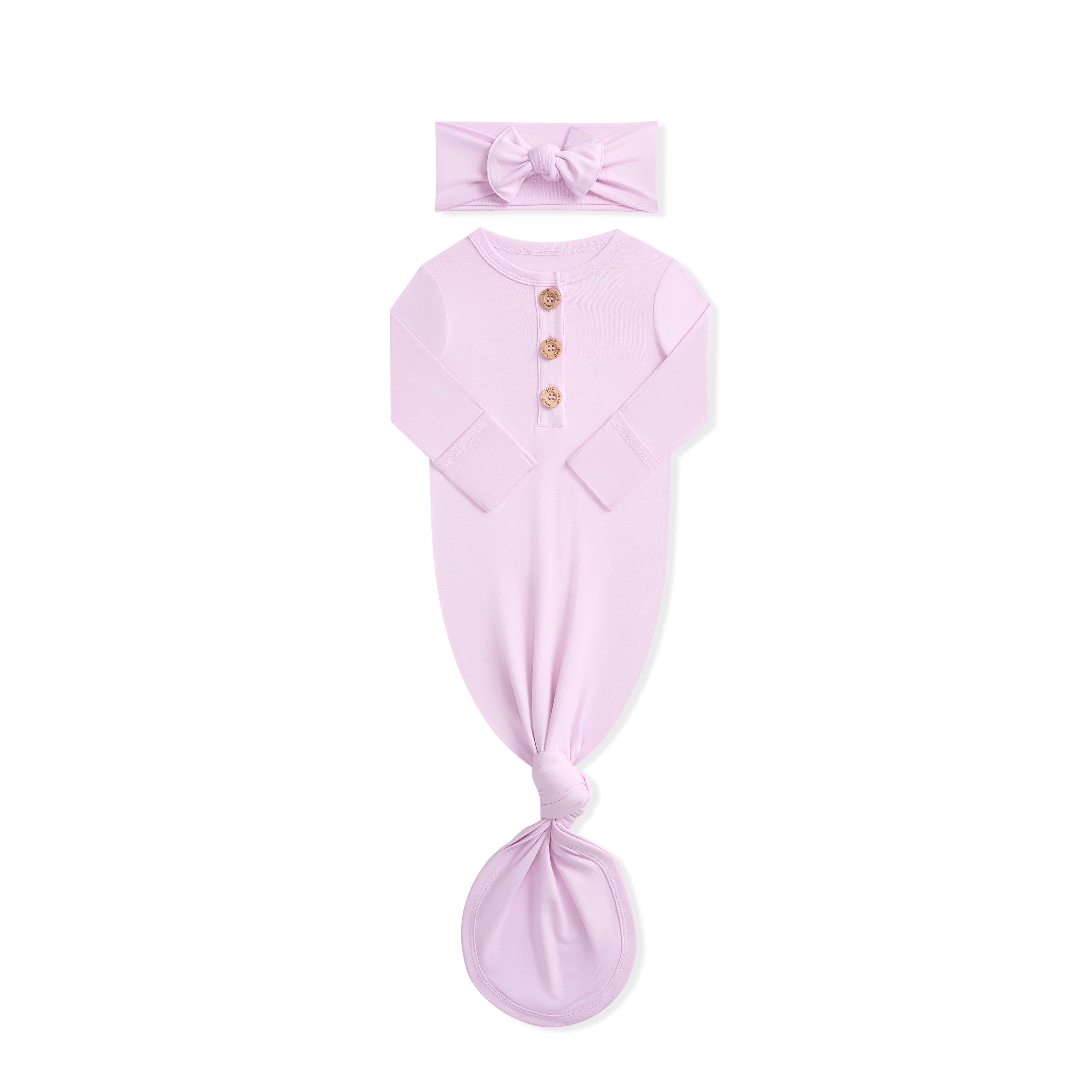 Pink baby gown and headband set on a white background