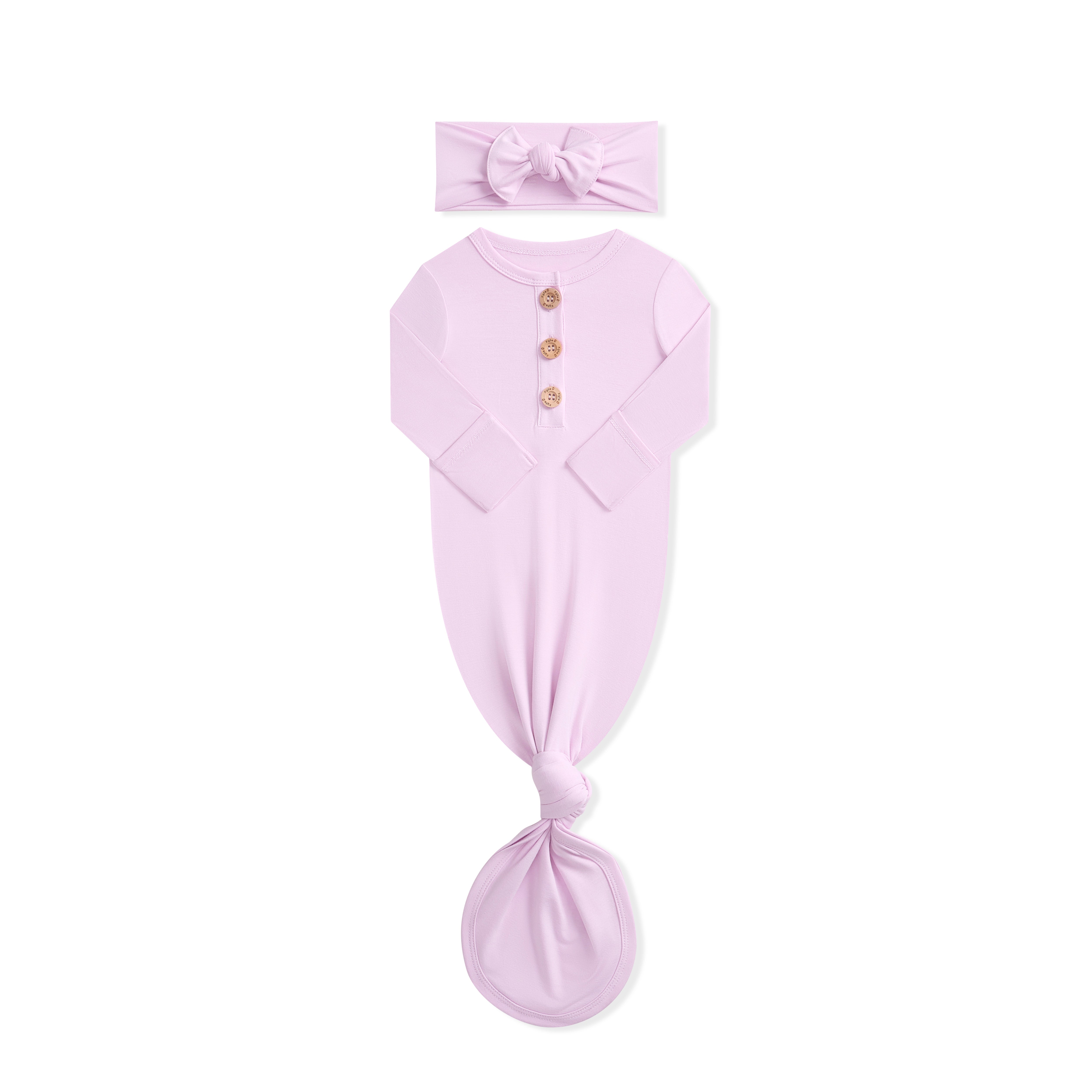 Pink baby gown and headband set on a white background