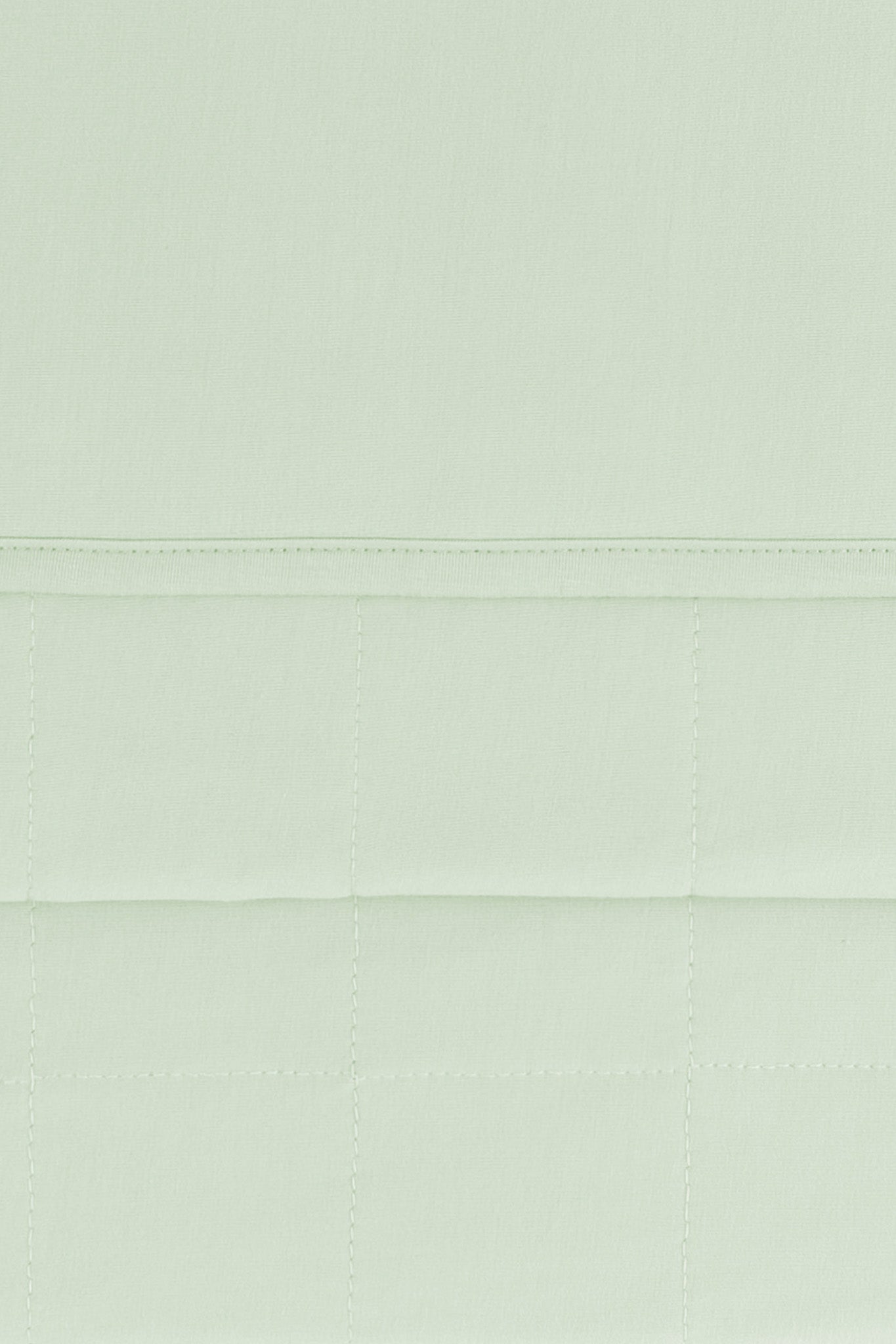 Close up of the quilted bottom and smooth top layer of the Adult Quilted Blanket in Basil 1.0