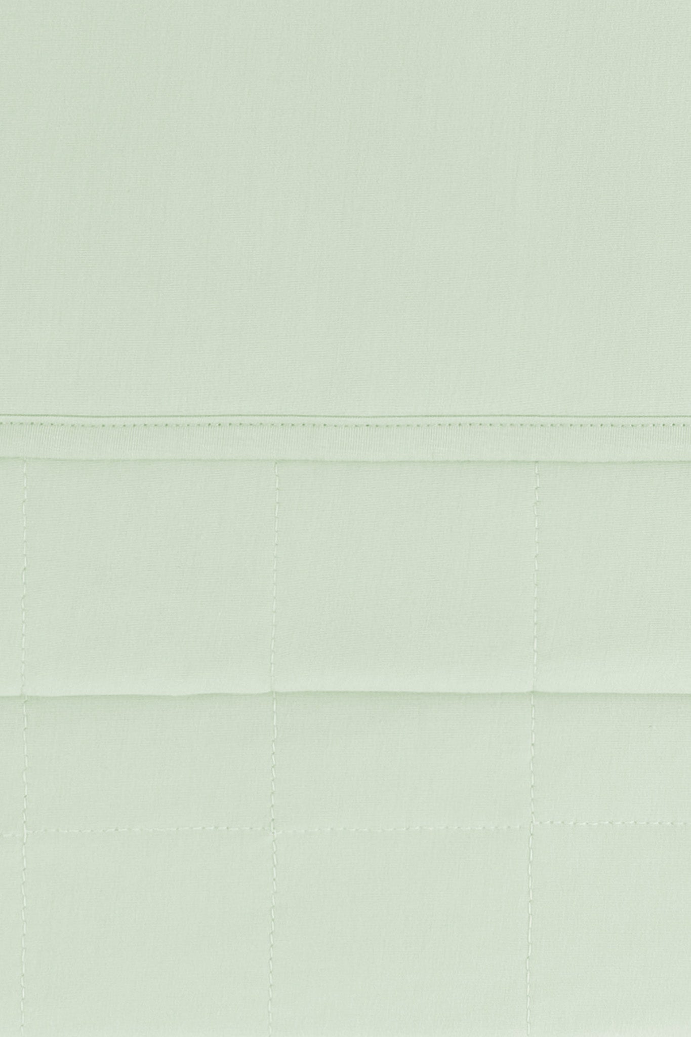 Close up of the quilted bottom and smooth top layer of the Adult Quilted Blanket in Basil 2.5