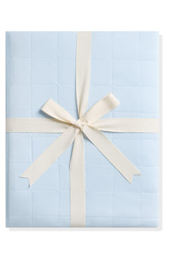 Product photo of the Adult Quilted Blanket in Breeze 1.0 shown tied in its linen ribbon