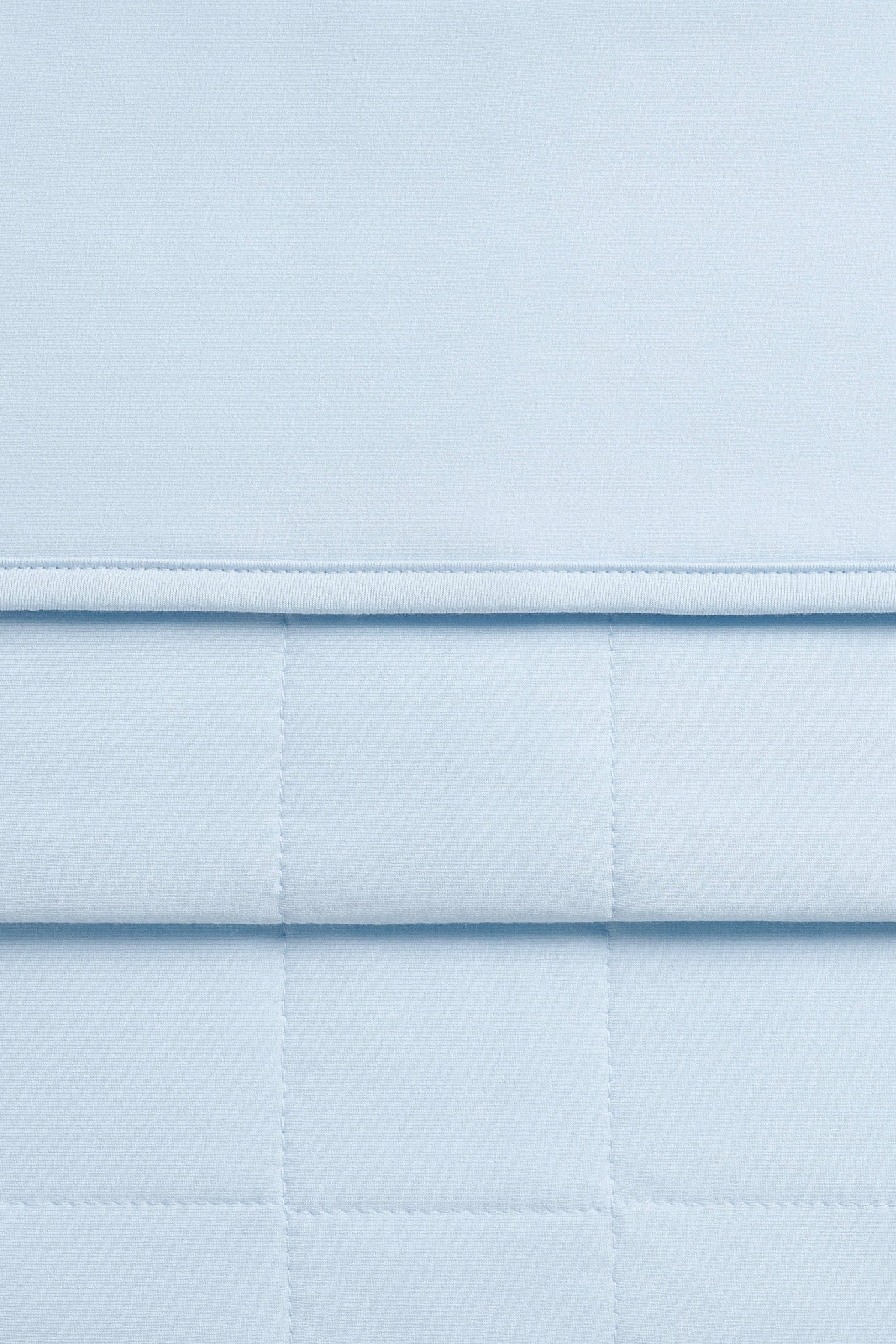 Close up of quilted backing and smooth top side of the Adult Quilted Blanket in Breeze 1.0