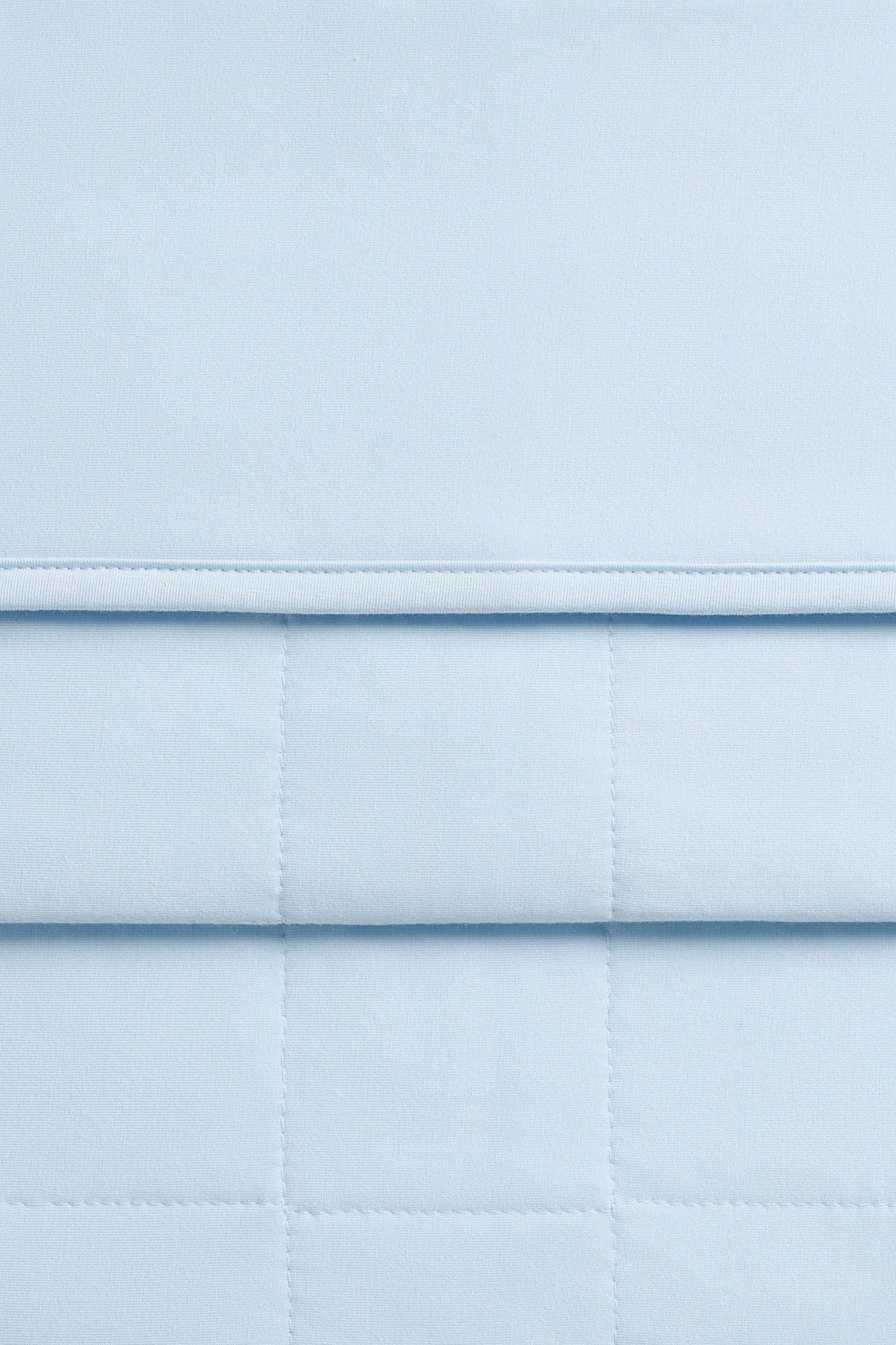 Close up of quilted backing and smooth top side of the Adult Quilted Blanket in Breeze 1.0