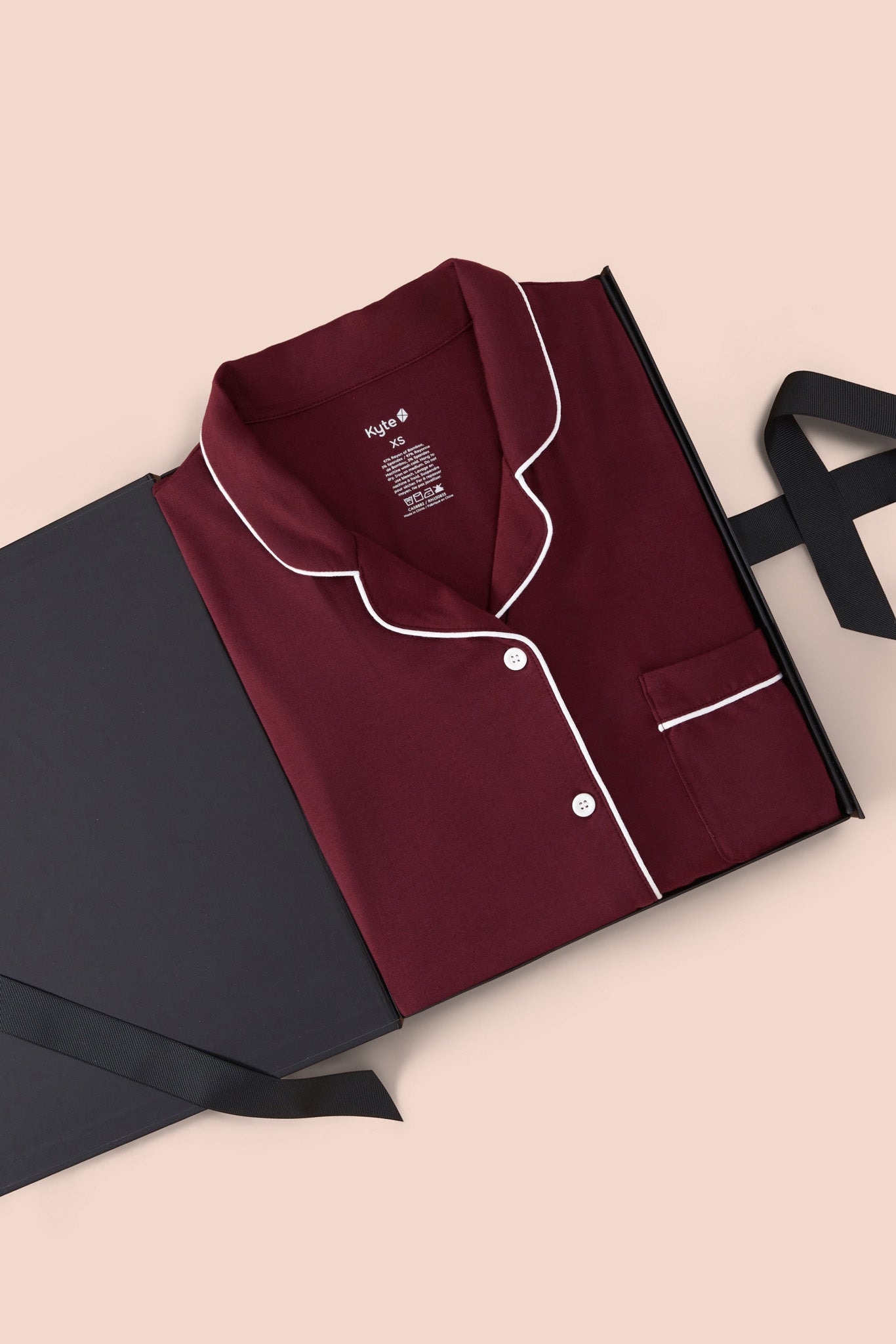 Long-Sleeved Women's Pajama Set in Burgundy with Cloud Trim packed in a box on a beige background