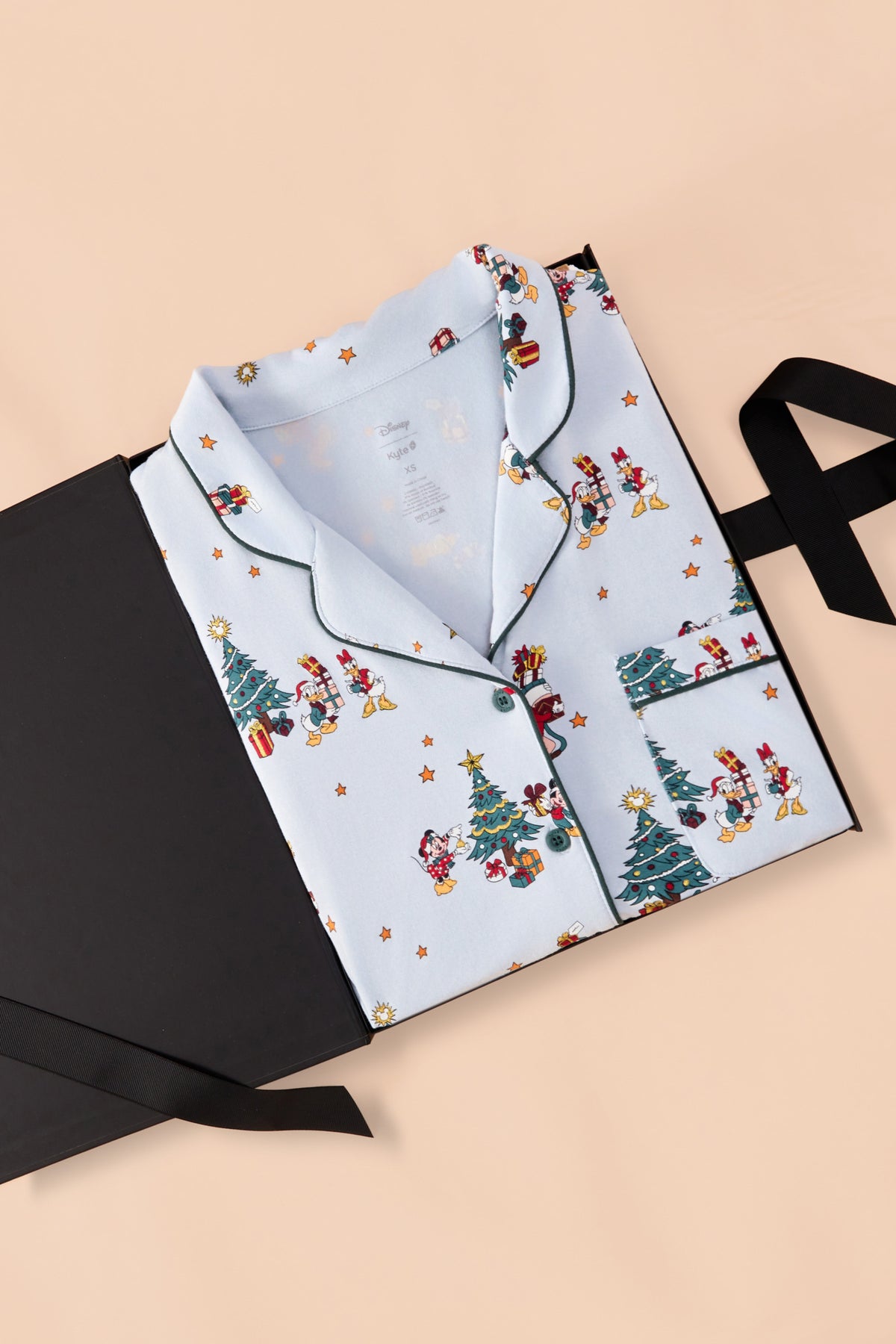 Long-Sleeved Women's Pajama Set in Mickey & Friends Christmas print packed in a black box on a beige background