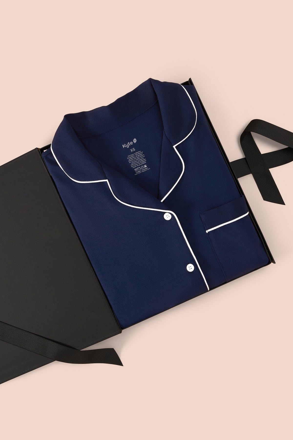 Long-Sleeved Women's Pajama Set in Navy with Cloud Trim packed in a box on a beige background