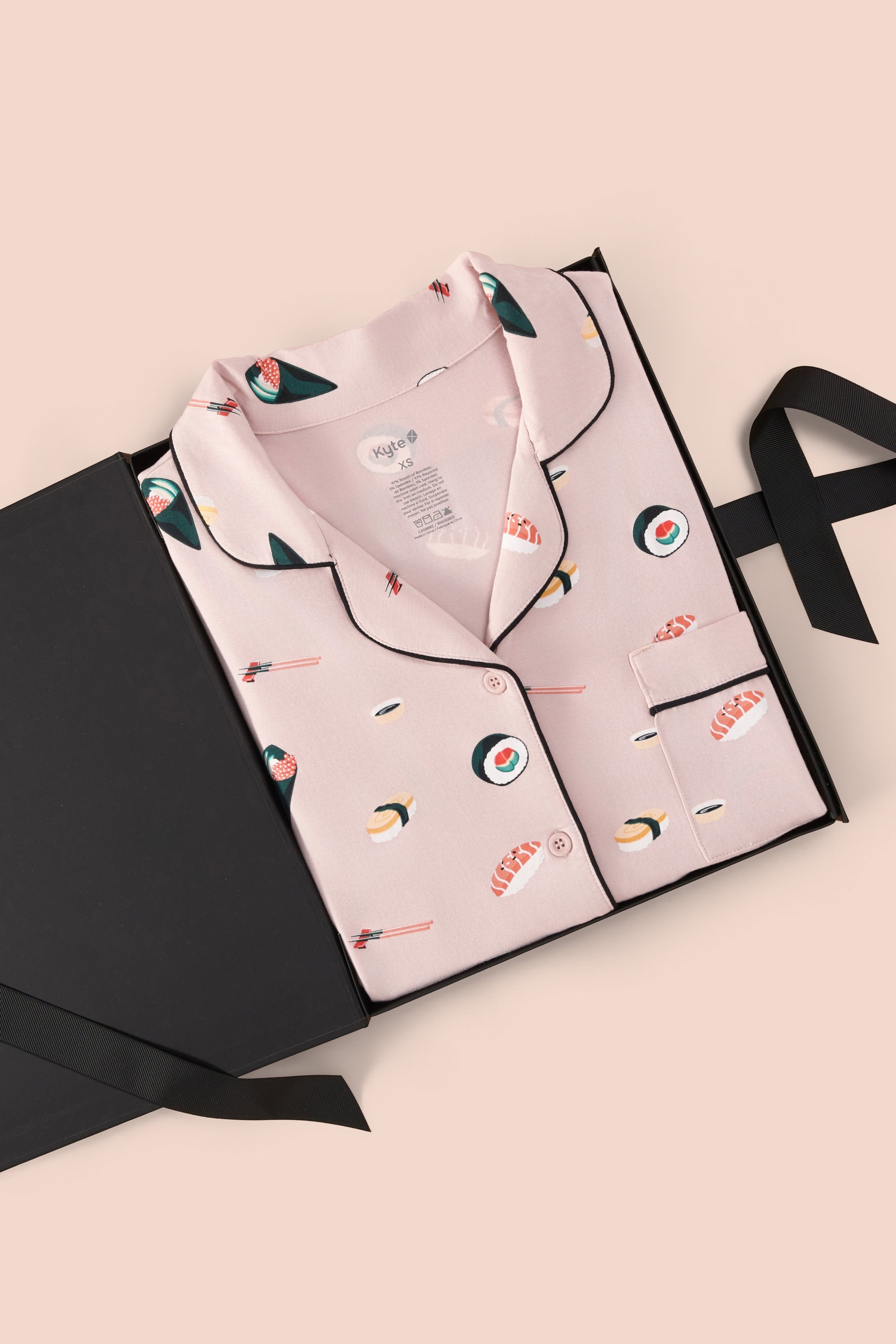 Long-Sleeved Women's Pajama Set in Blush Sushi print packed in a box on a beige background