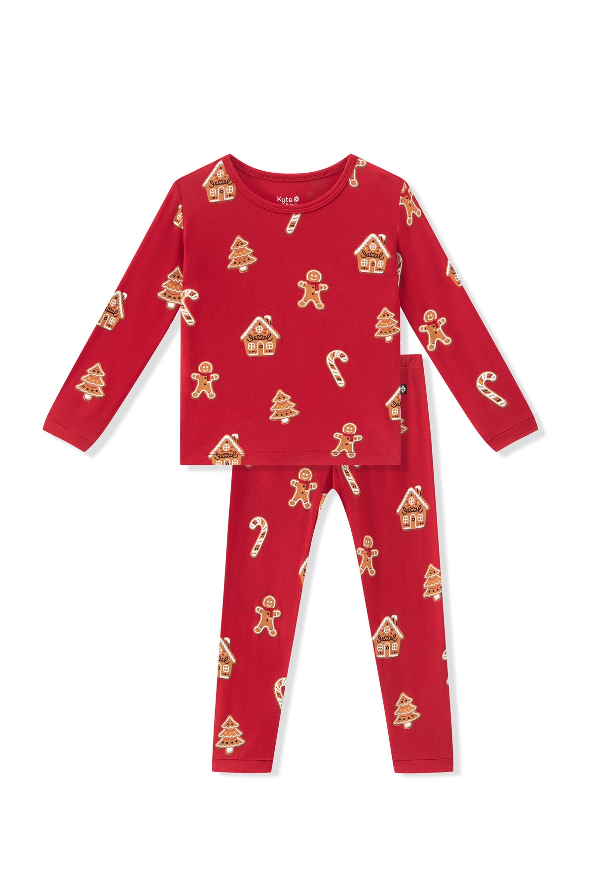 A two-piece children's pajama set in bright red, featuring a long-sleeve top and matching pants with an all-over gingerbread-themed print of gingerbread men, houses, candy canes, and Christmas trees.