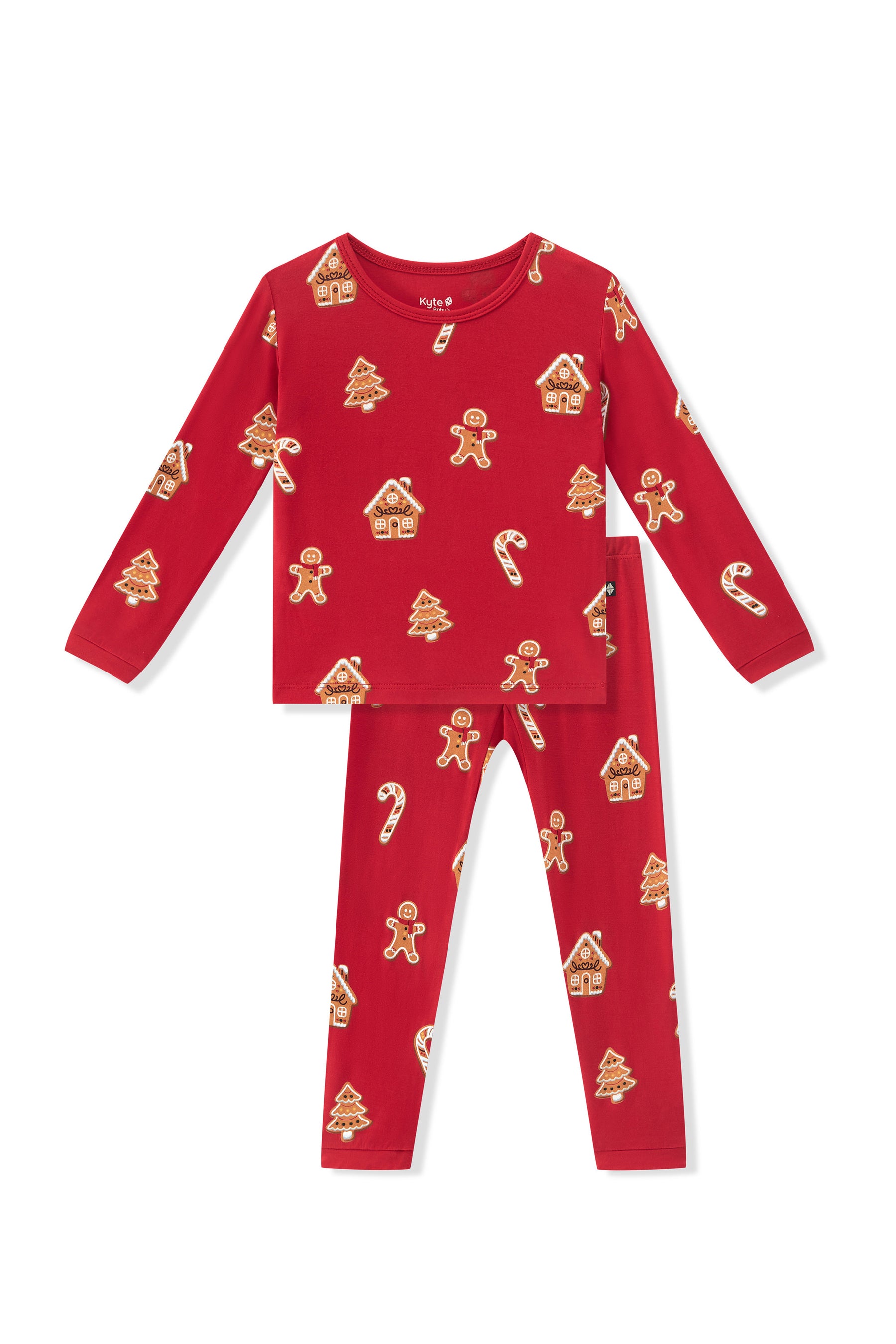 A two-piece children's pajama set in bright red, featuring a long-sleeve top and matching pants with an all-over gingerbread-themed print of gingerbread men, houses, candy canes, and Christmas trees.