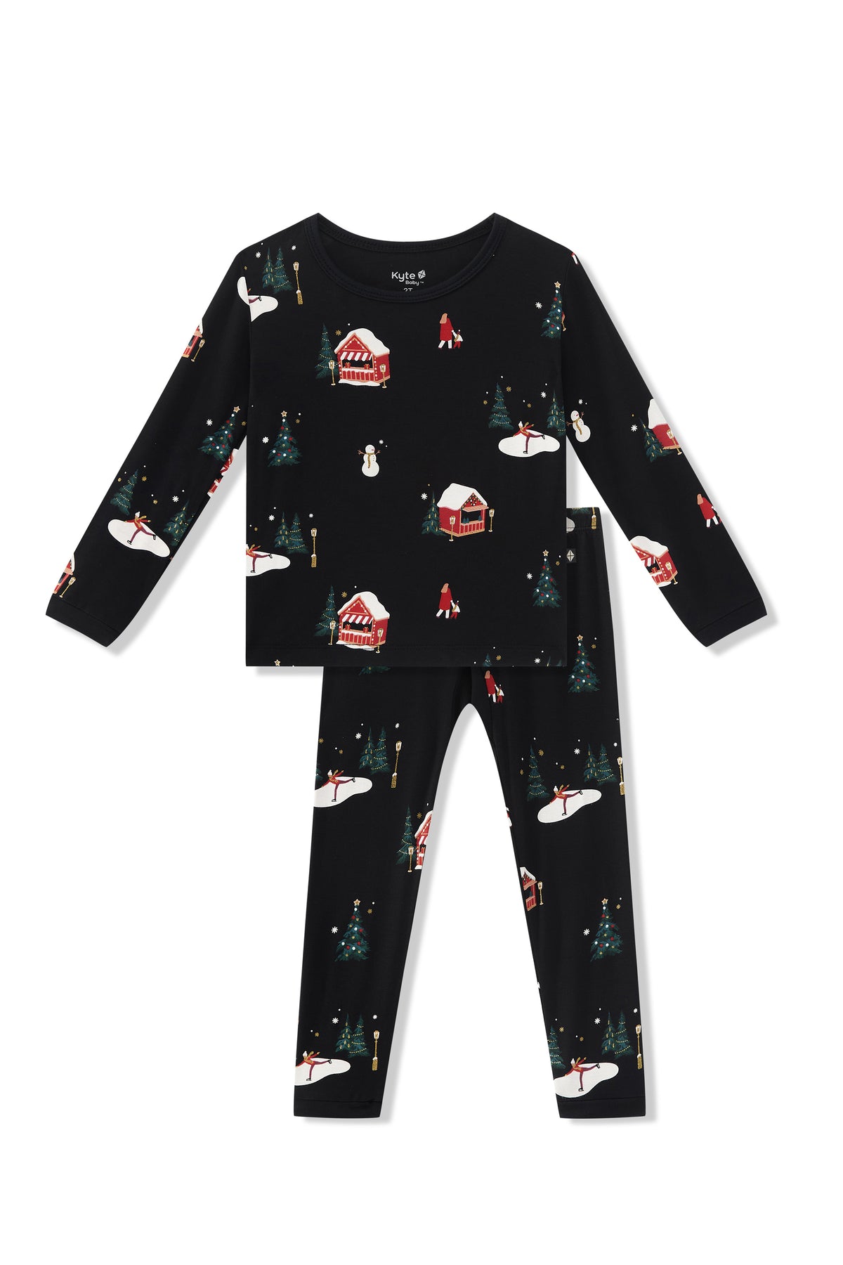 A two-piece children's pajama set  featuring a long-sleeve top and matching pants in black with a festive winter holiday print of snow-covered cabins, Christmas trees, and snowmen.