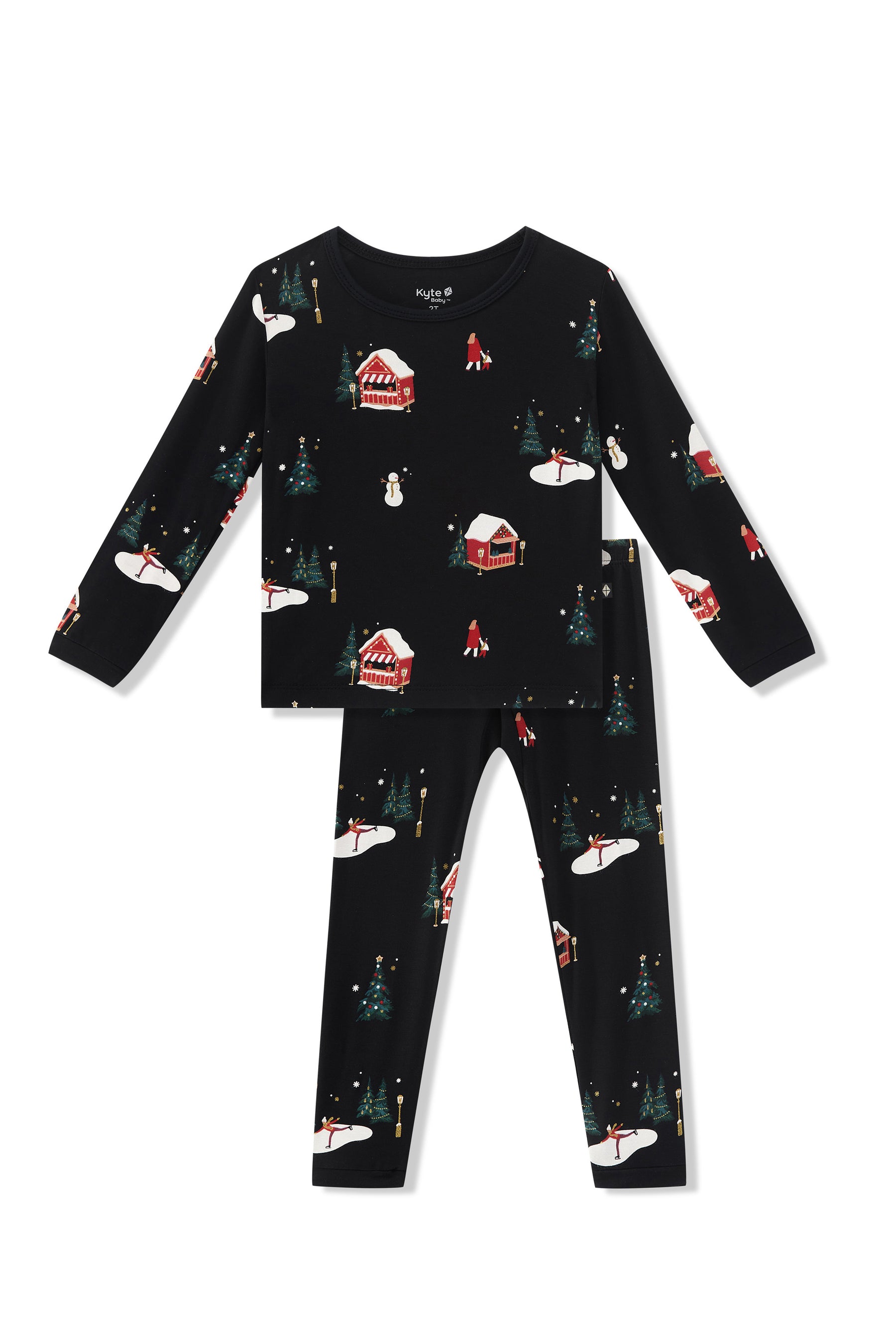 A two-piece children's pajama set  featuring a long-sleeve top and matching pants in black with a festive winter holiday print of snow-covered cabins, Christmas trees, and snowmen.