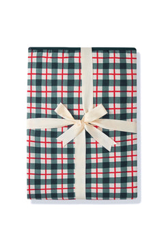 A youth blanket in a green, red, and white plaid pattern, tied with a cream-colored satin ribbon and bow, set against a plain white background.