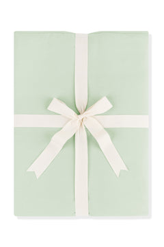 Youth Blanket in Basil 1.0 shown wrapped in its packaging tied with a linen bow