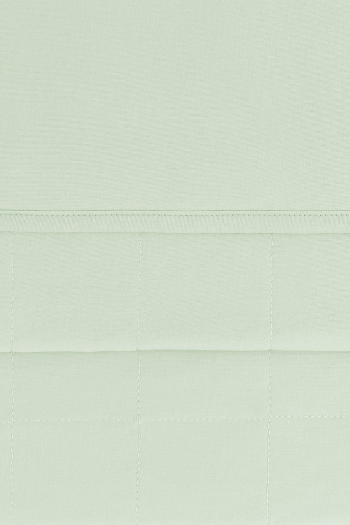 Close up of the Youth Blanket in Basil 1.0 showing the quilted backing and smooth top layer