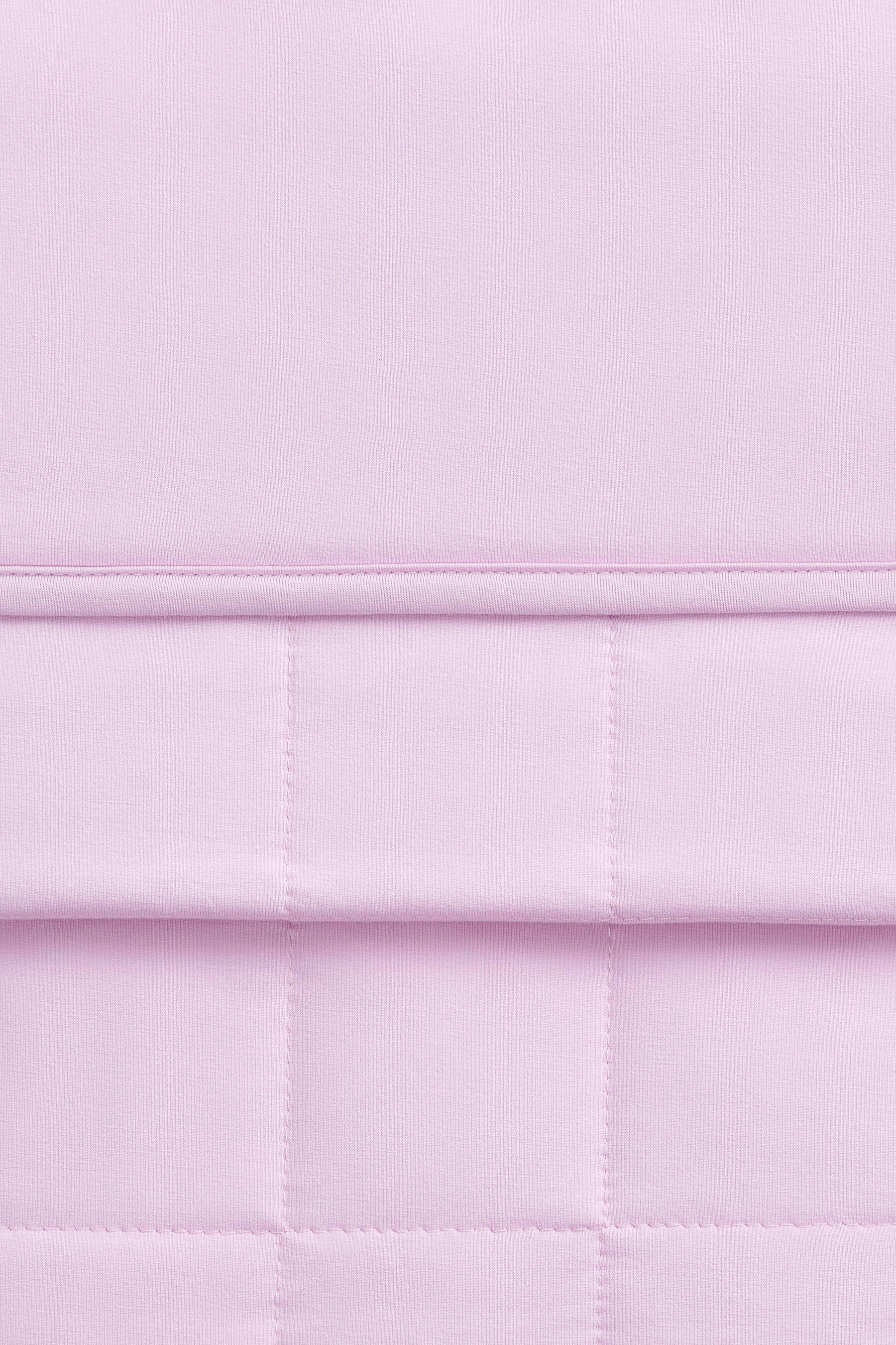 Close up of the Youth Blanket in Thistle 1.0 showing the quilted backing and smooth top layer