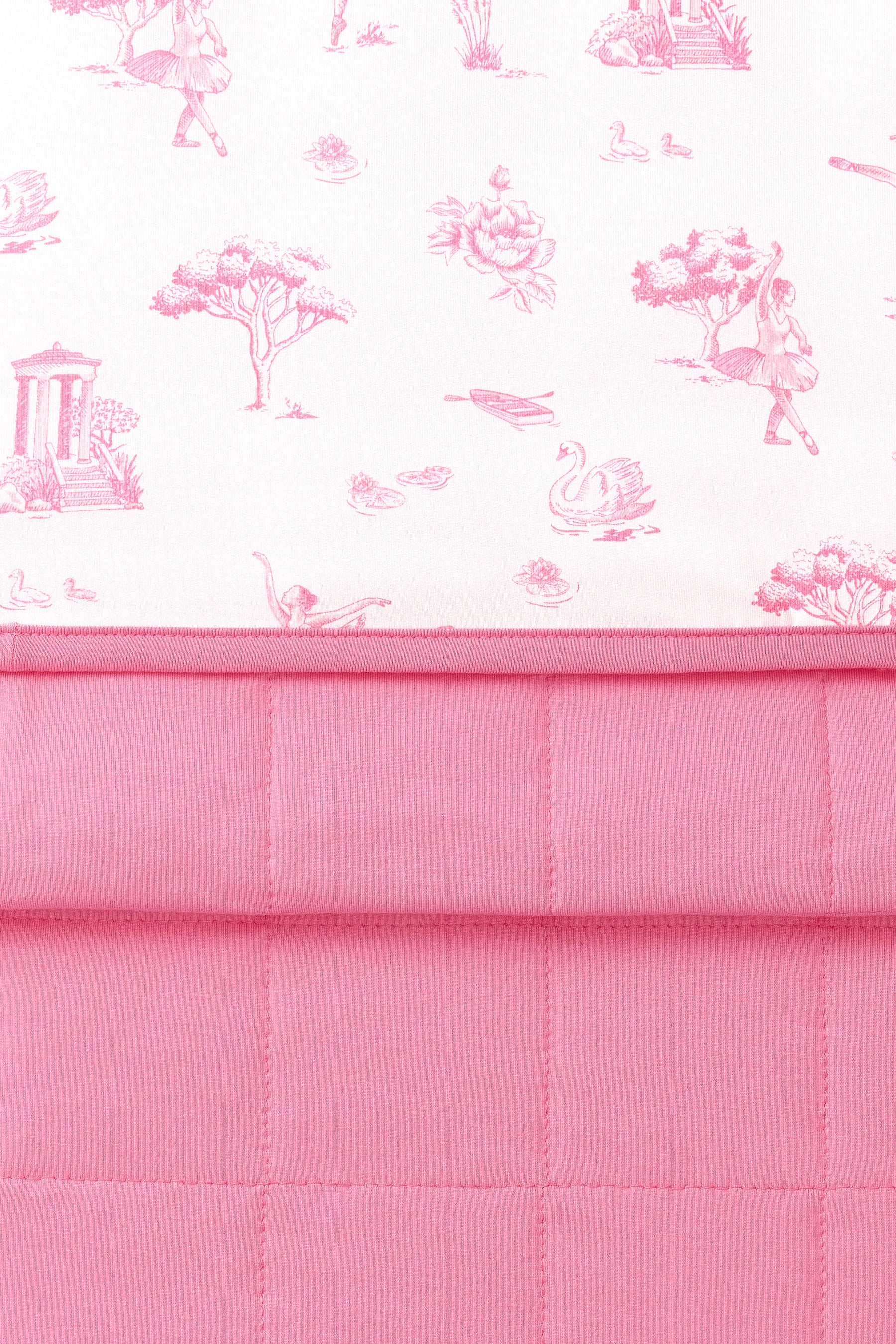 Close up of the Youth Blanket in Toile Ballet 1.0 showing the pink quilted backing and smooth printed top layer