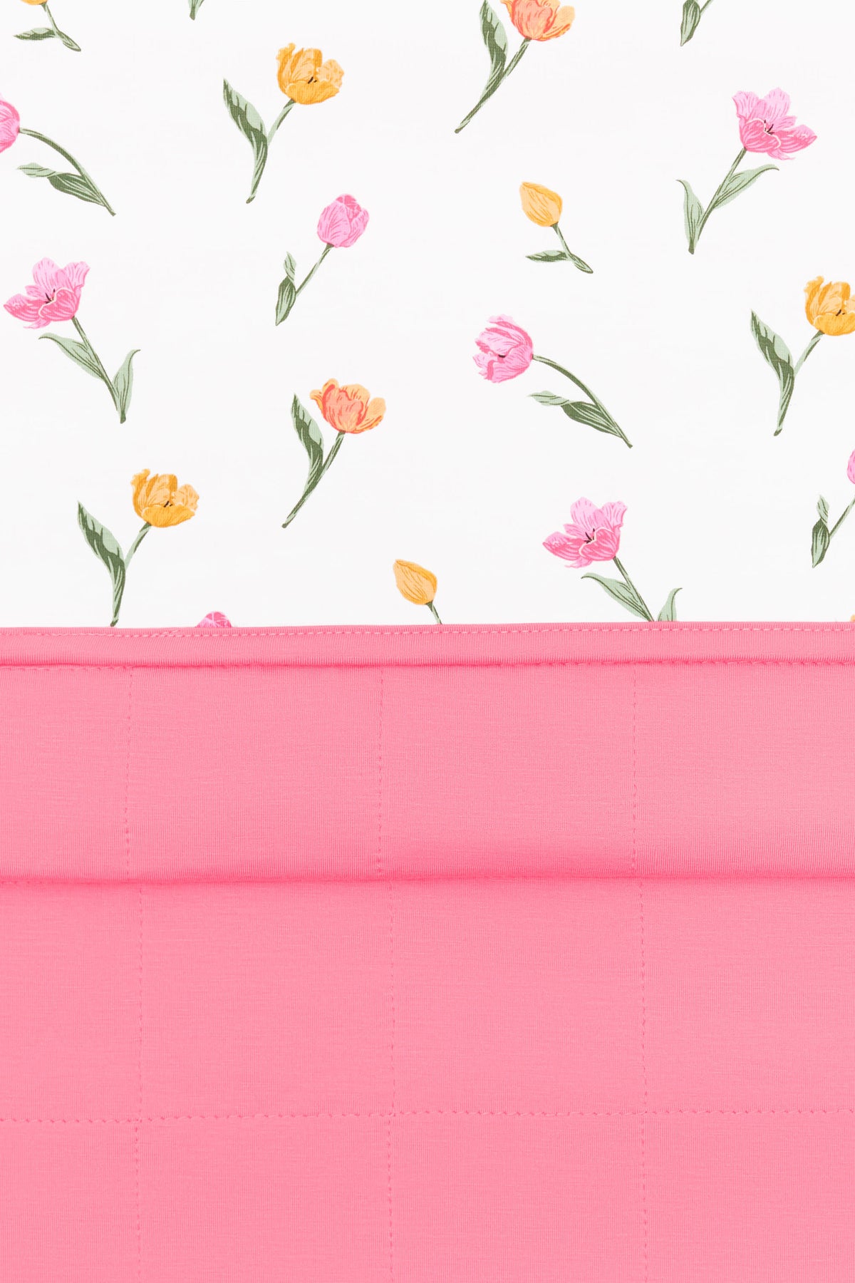 Close up of the Youth Blanket in Tulip 1.0 showing the quilted pink backing and floral smooth top layer