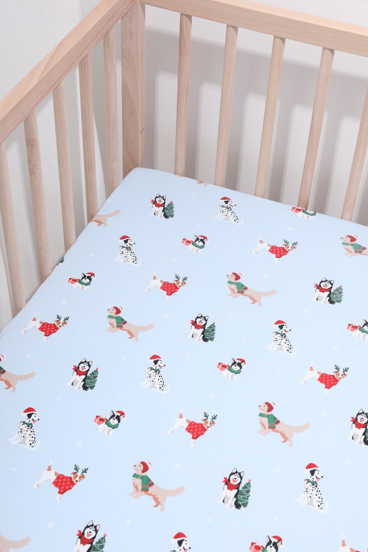 Blue Crib Sheet in Holiday Pups print in a crib