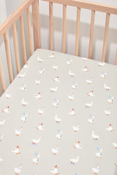 Crib Sheet placed in Oat Silly Goose print in a crib