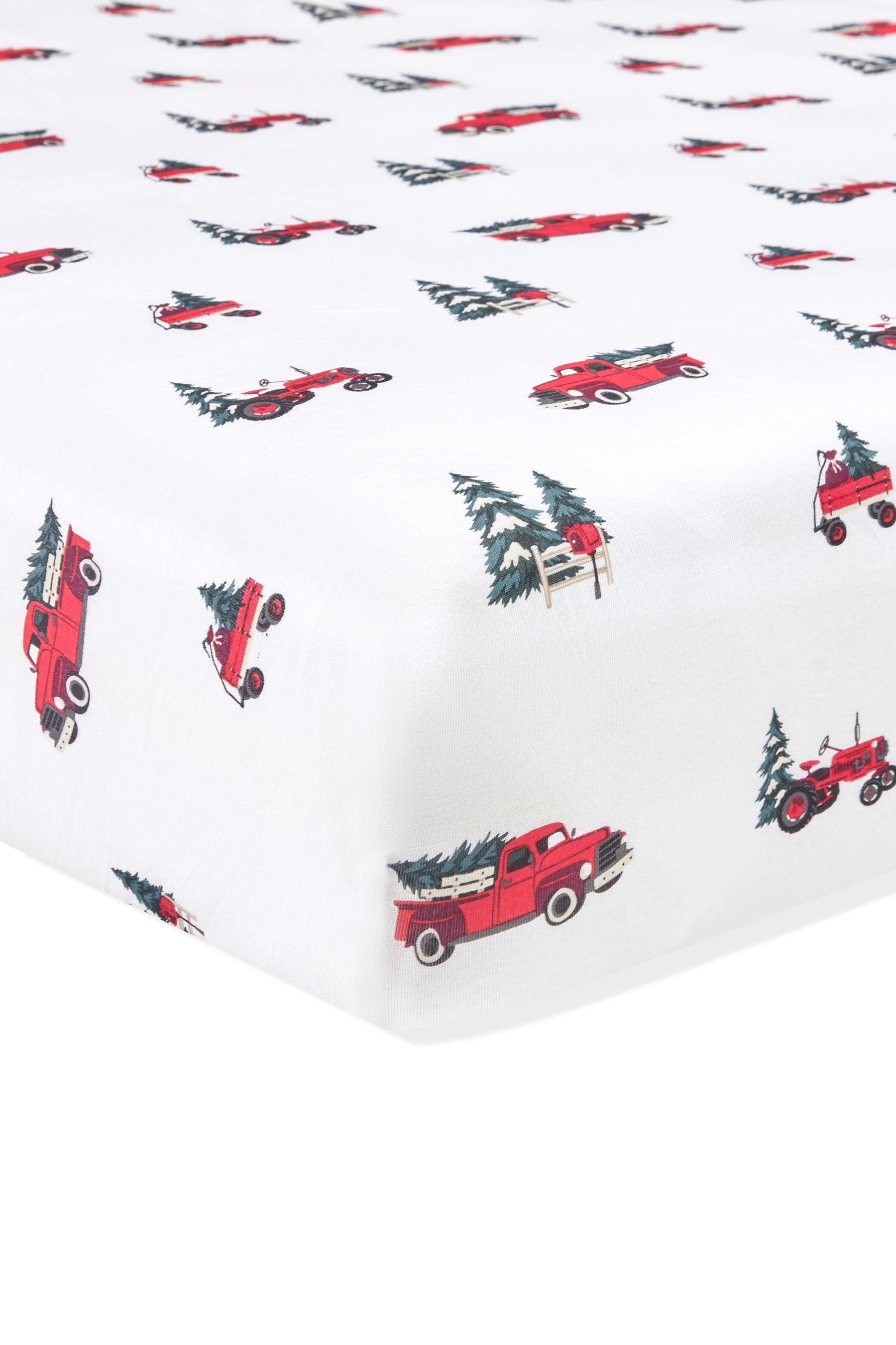 White fitted sheet with a repeating pattern of red vintage pickup trucks carrying Christmas trees and small evergreen trees.