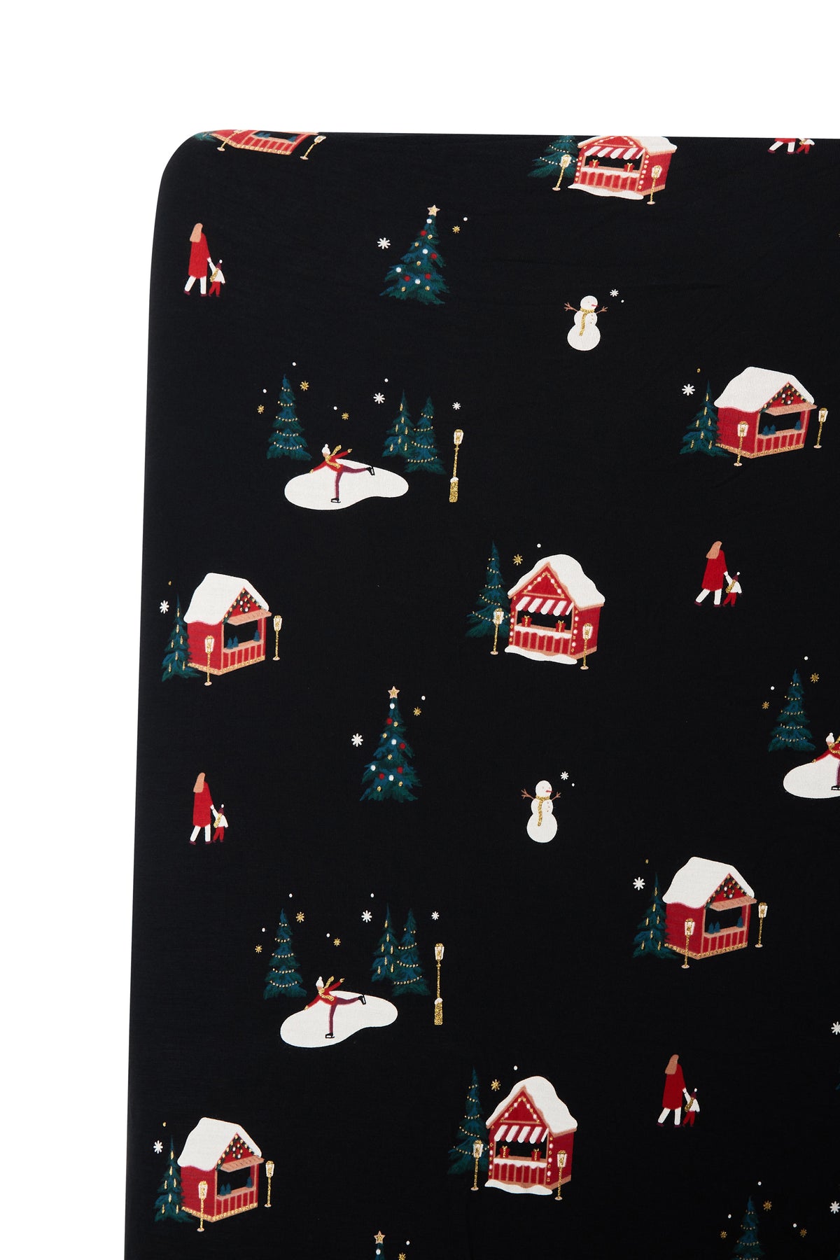 A close-up of a black fabric or wallpaper pattern featuring a winter holiday scene with red cabins, snow-covered trees, snowmen, and small figures in red and white clothing.