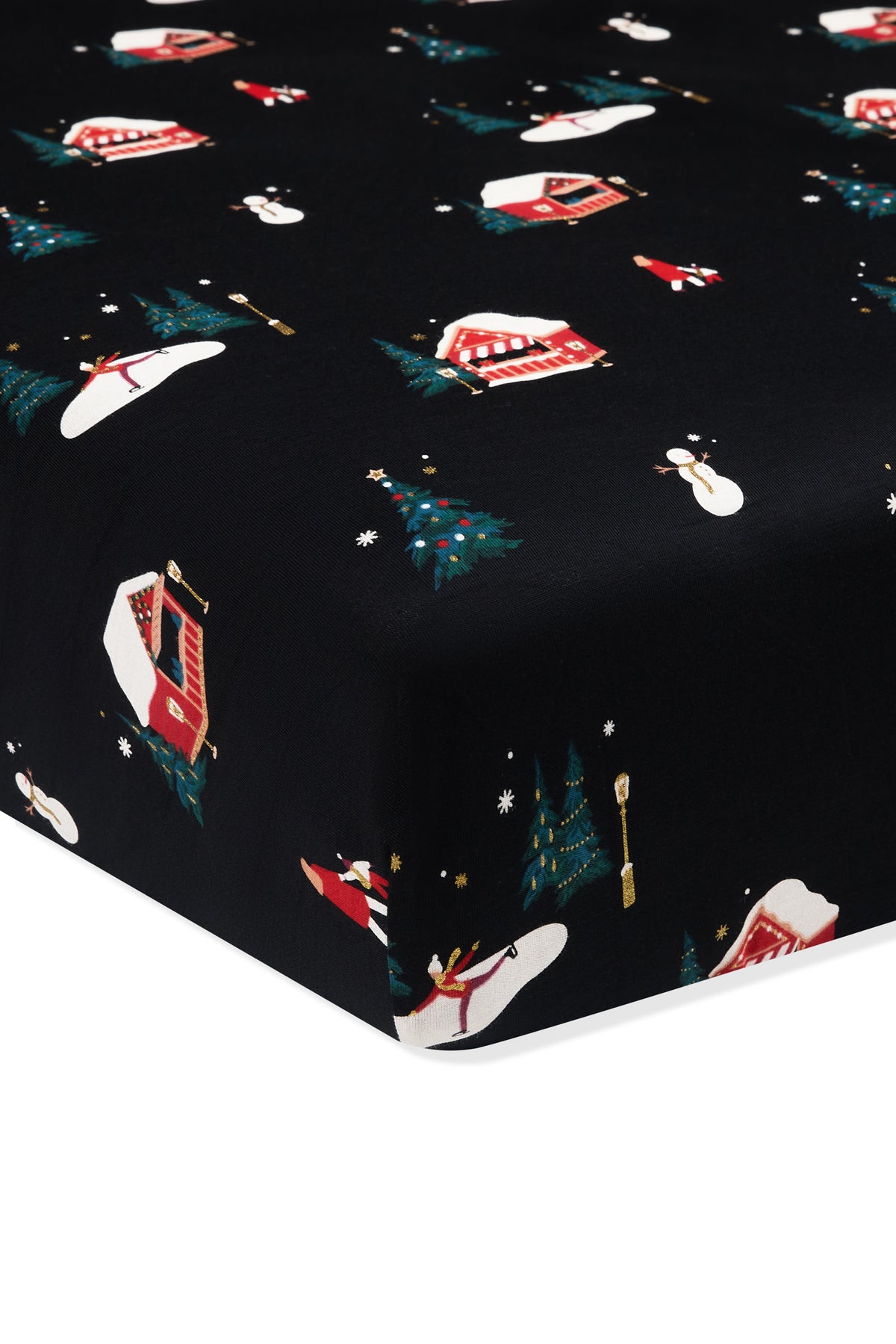 A close-up of a fitted sheet or mattress cover with a black background and a festive Christmas print featuring red and white campers, snowmen, evergreen trees, and snowflakes.