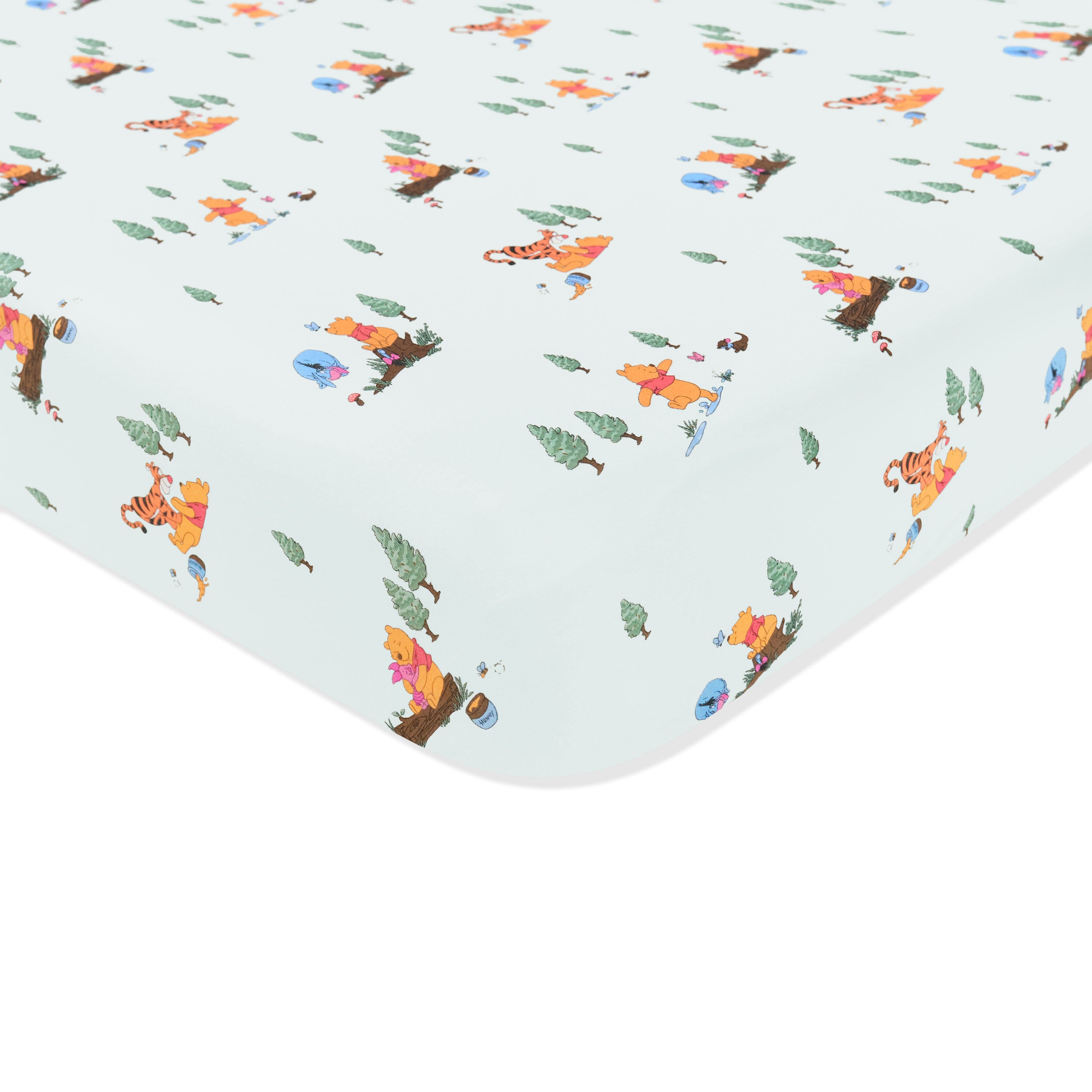 Corner of the Crib Sheet in Winnie the Pooh Hundred Acre Wood shown on a crib mattress