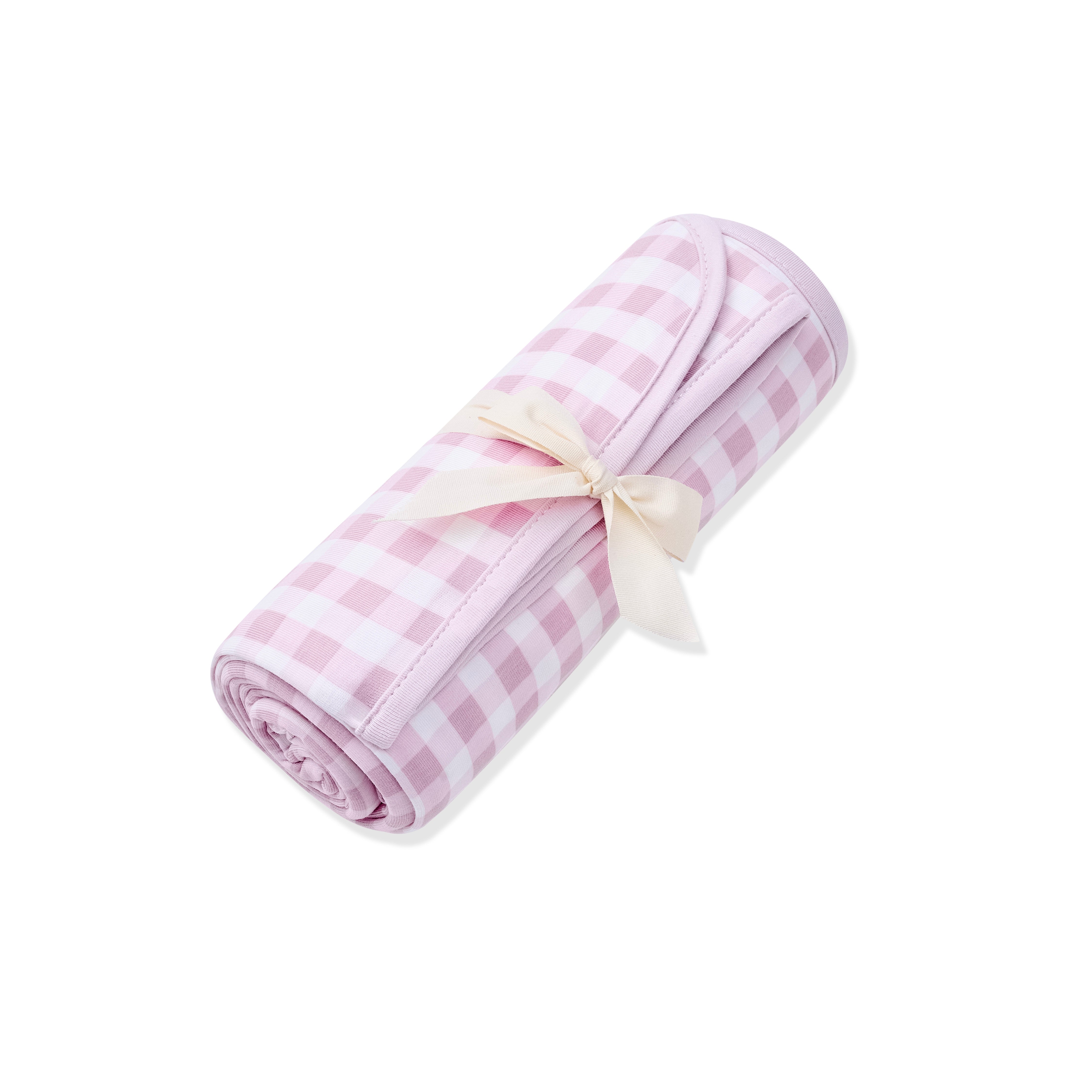 Swaddle Blanket in Gingham Thistle shown rolled in its packaging tied with a linen bow