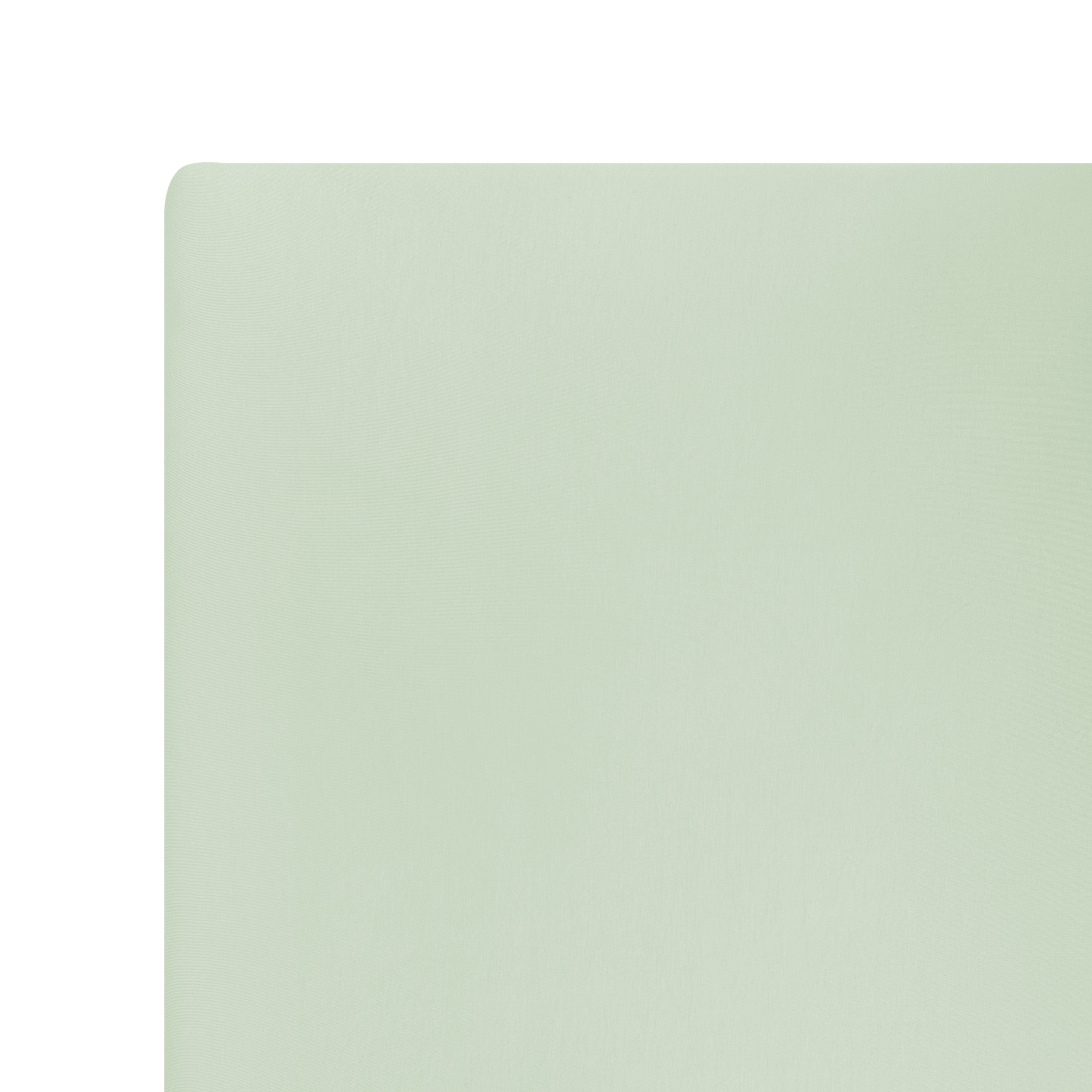 Close up of the corner of the Twin Sheet in Basil shown on a mattress