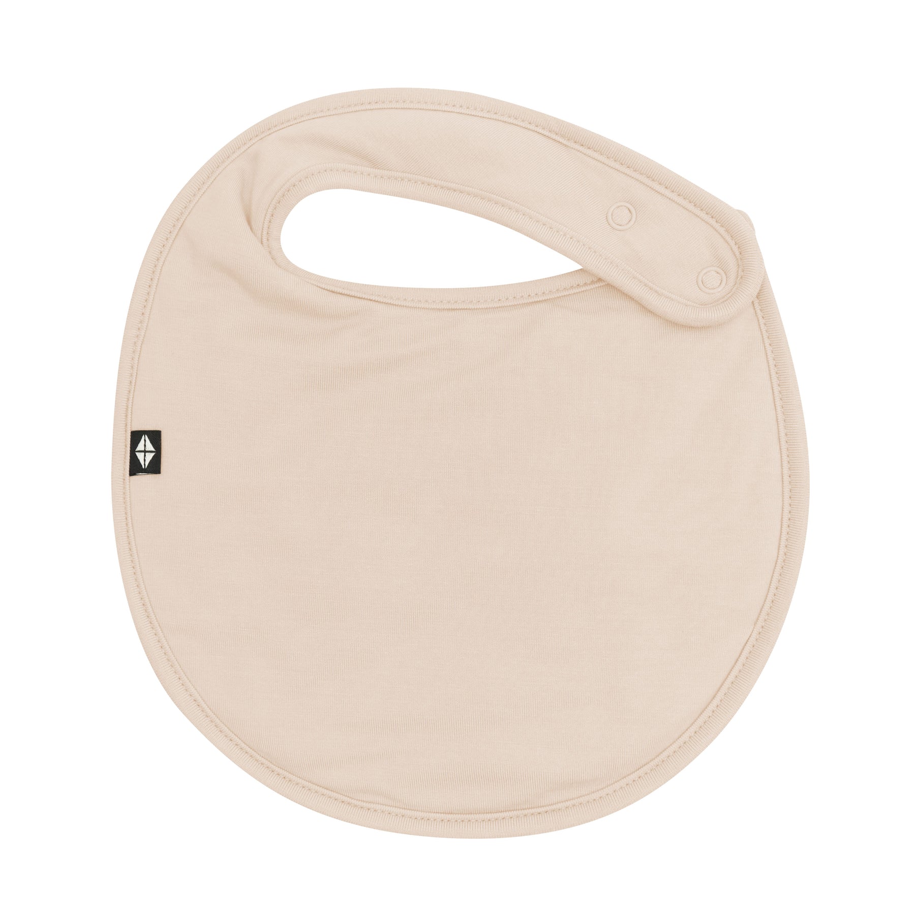 The front of the Cushy Bib in Bisque showing the snap closures