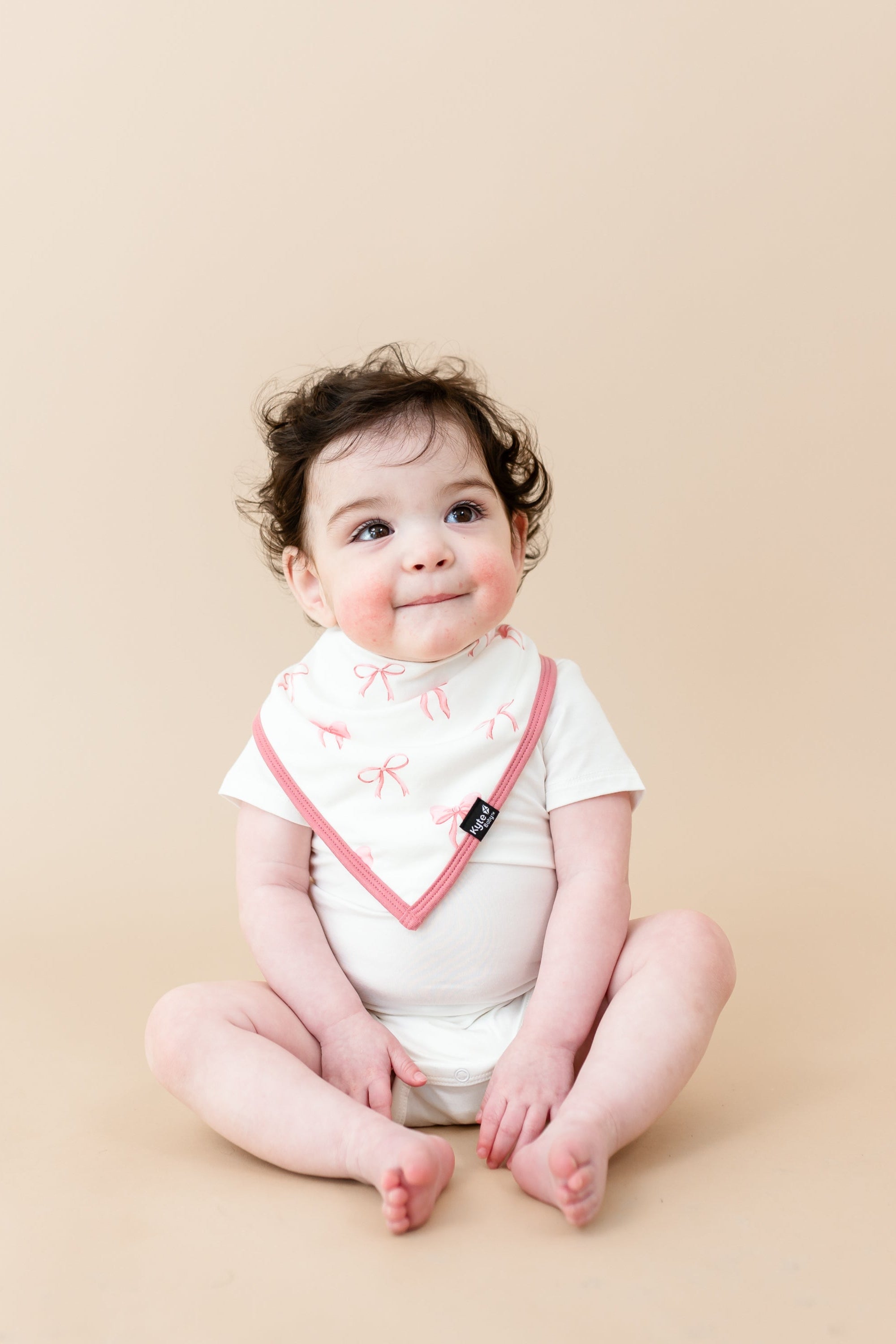 Toddler sitting wearing Cloud Bodysuit and Bib in Bow