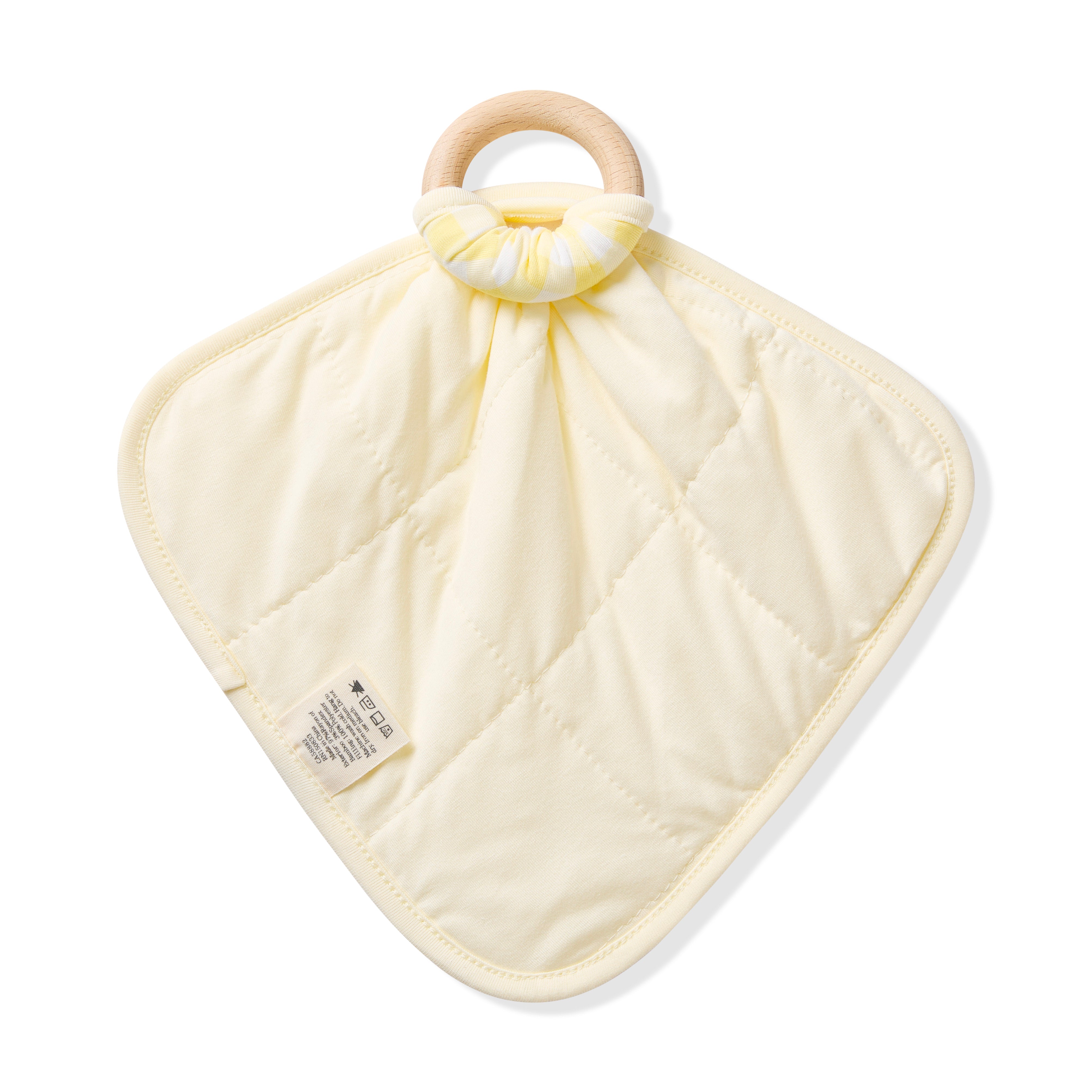The quilted light yellow backing of the Lovey in Gingham Chamomile with Removable Wooden Teething Ring shown tied to a wooden ring