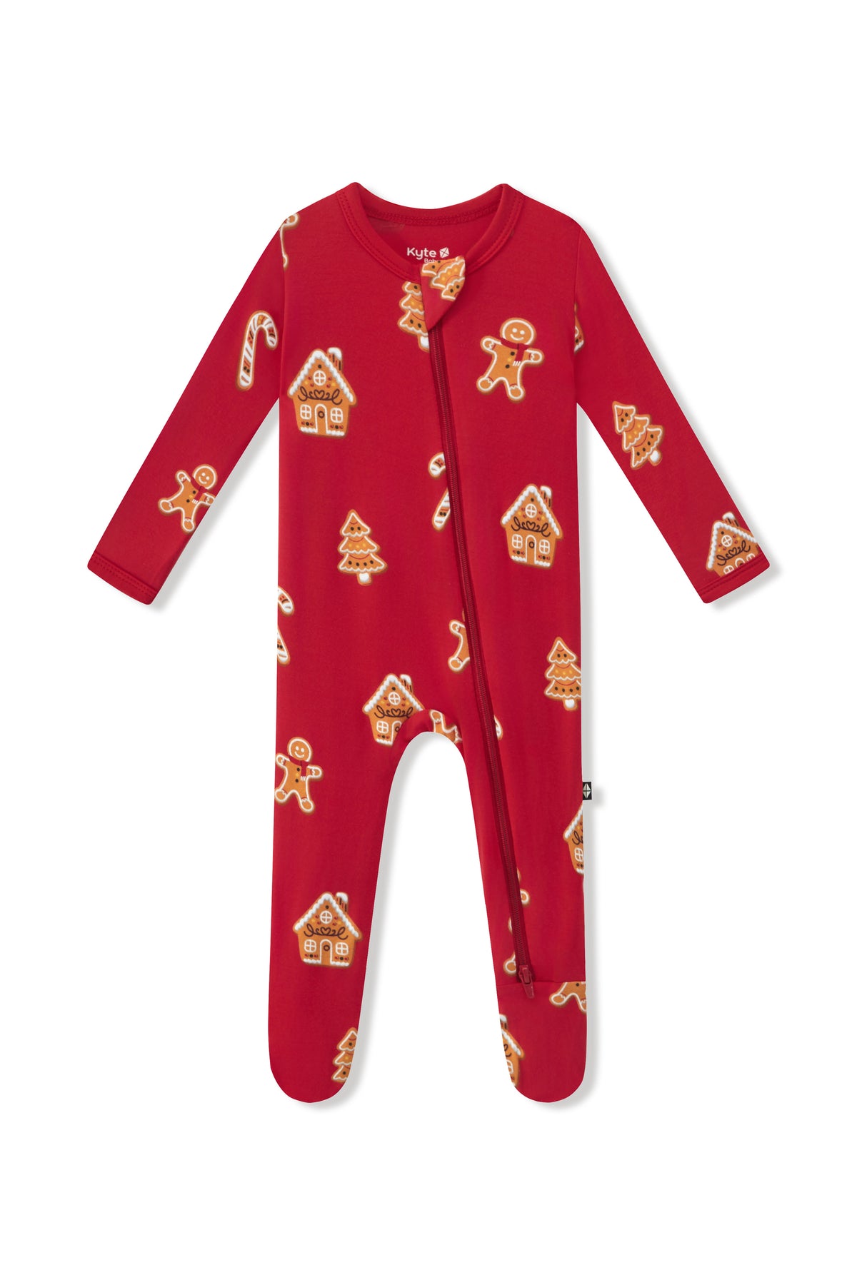 A red long-sleeve baby footie sleeper with an all-over gingerbread man and house pattern, featuring a front zipper closure.