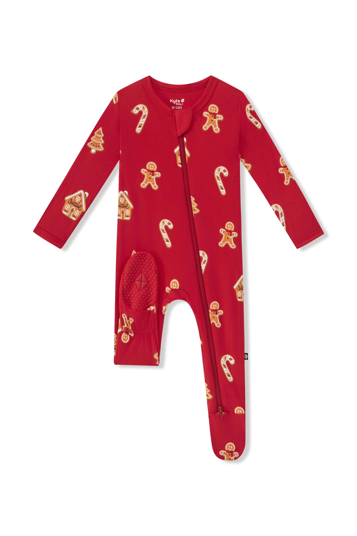 A red long-sleeve baby footed sleeper with a front zipper and an all-over holiday print of gingerbread men, candy canes, and gingerbread houses, shown on a plain white background.