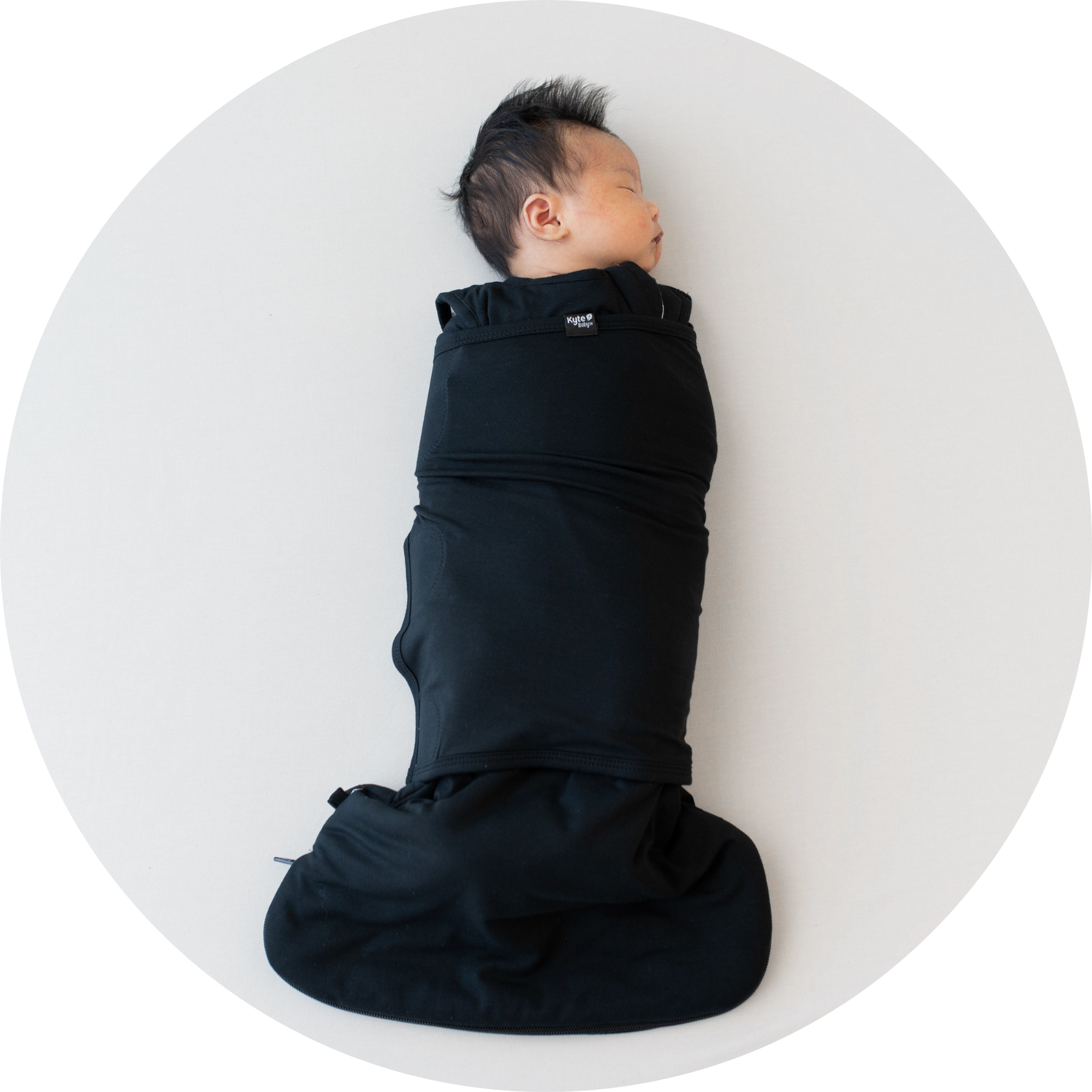 Image of baby sleeping in midnight sleep bag swaddler