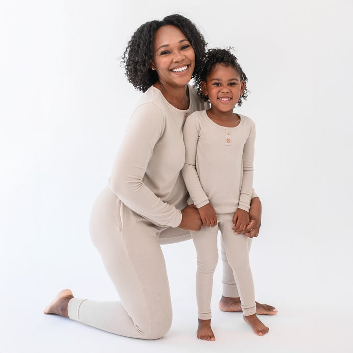 Mother kneeling beside her standing daughter holding her close both matching in the Ribbed Henley Sets in Bisque