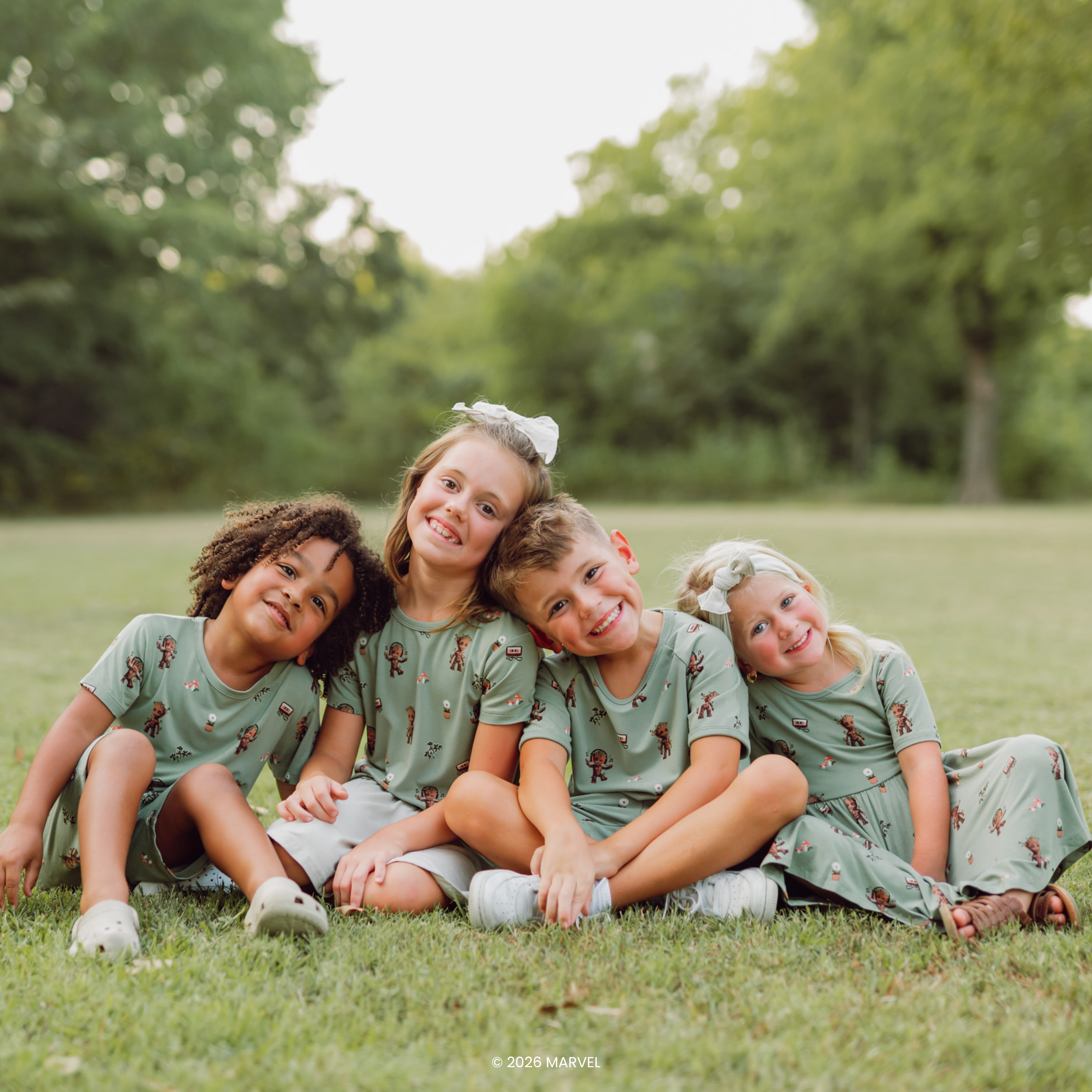 Group of 4 kids outside with trees in background wearing Kyte Baby Marvel Groot collection 