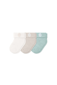 Three socks in Cloud, Oat, and Sage laying flat on a white background.