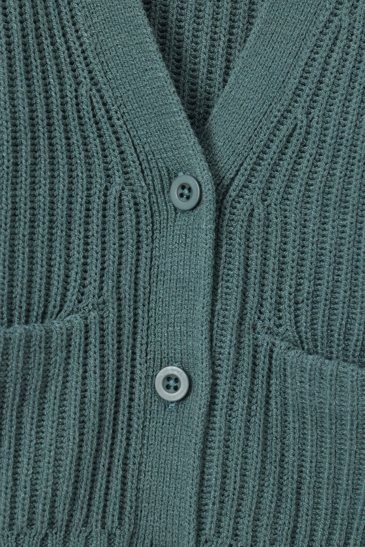 Close up of oversized green cardigan with button closure