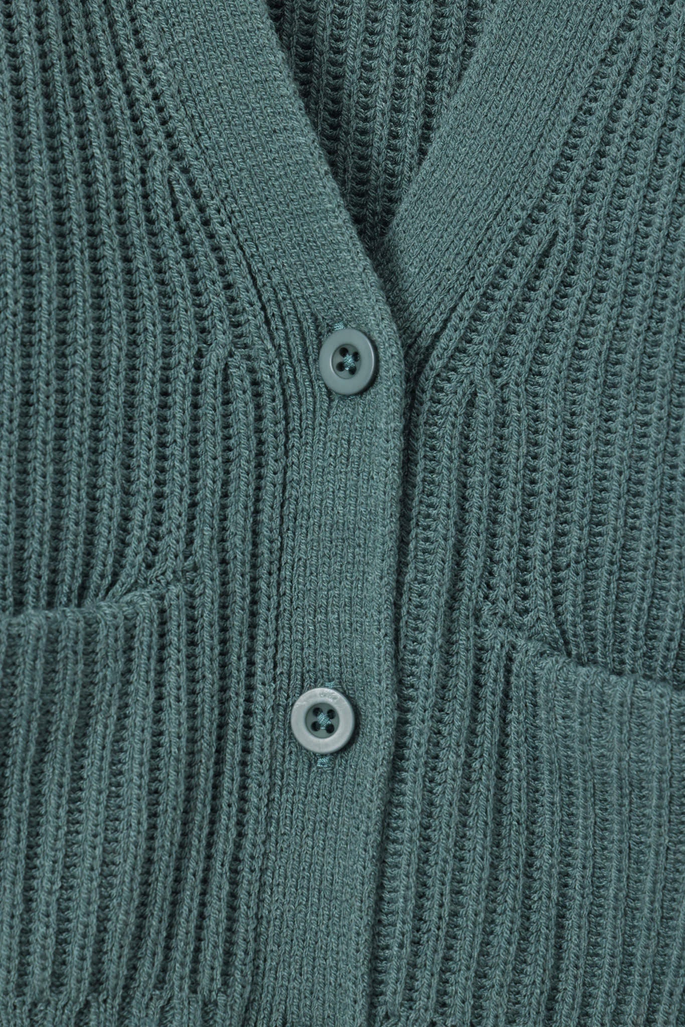 Close up of oversized green cardigan with button closure