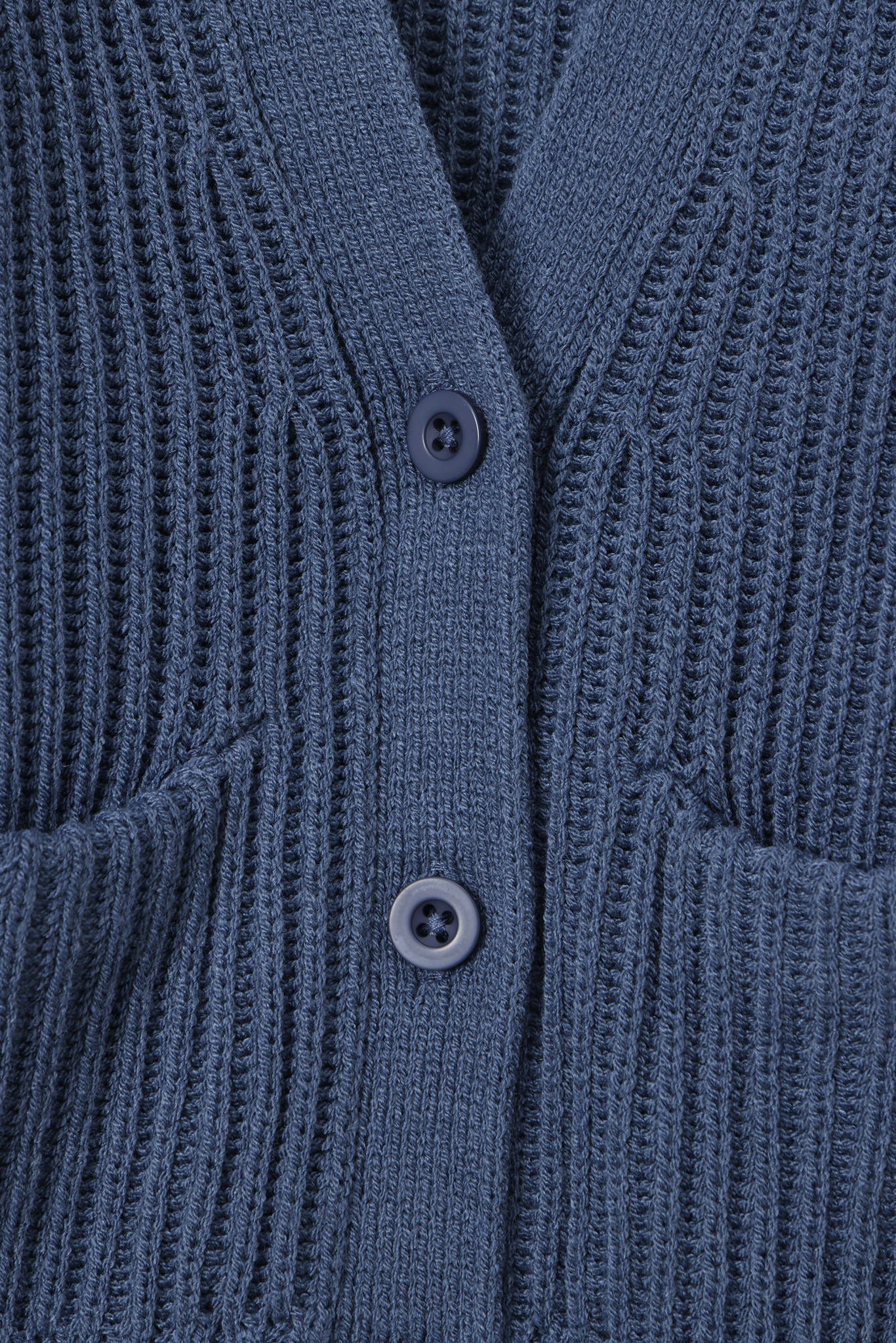 Close up of oversized blue cardigan with button closure