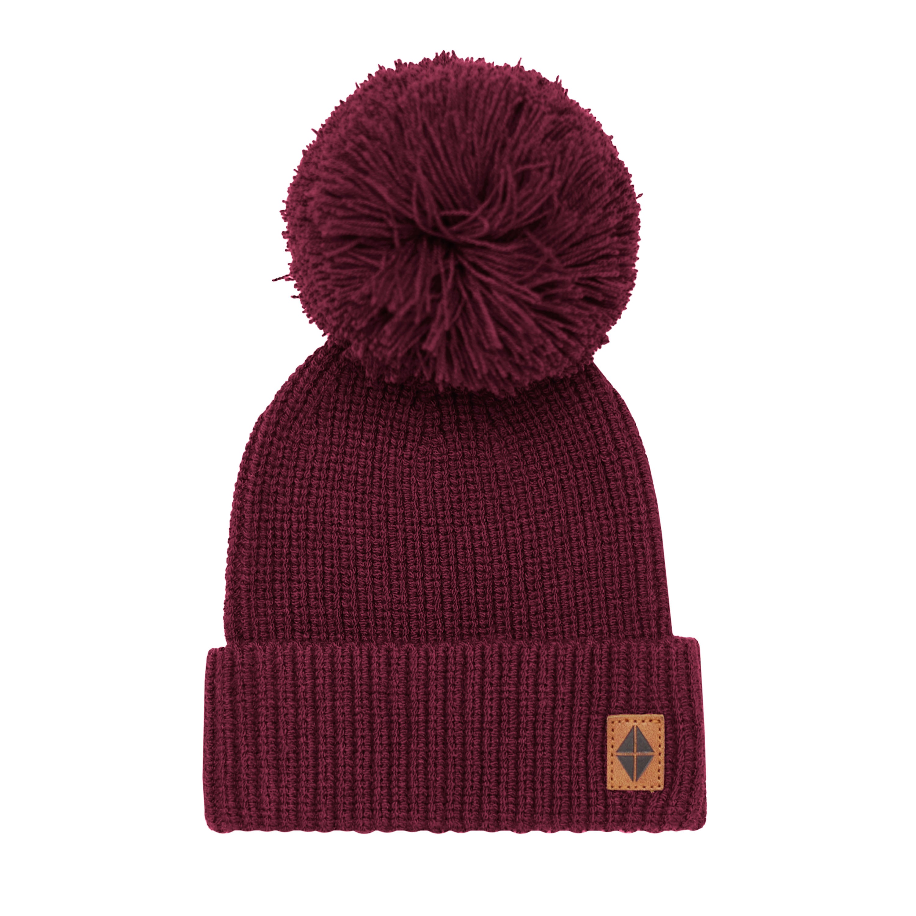 Product of the Chunky Knit Pom Beanie in Burgundy with the Kyte Baby Vegan leather tag visible