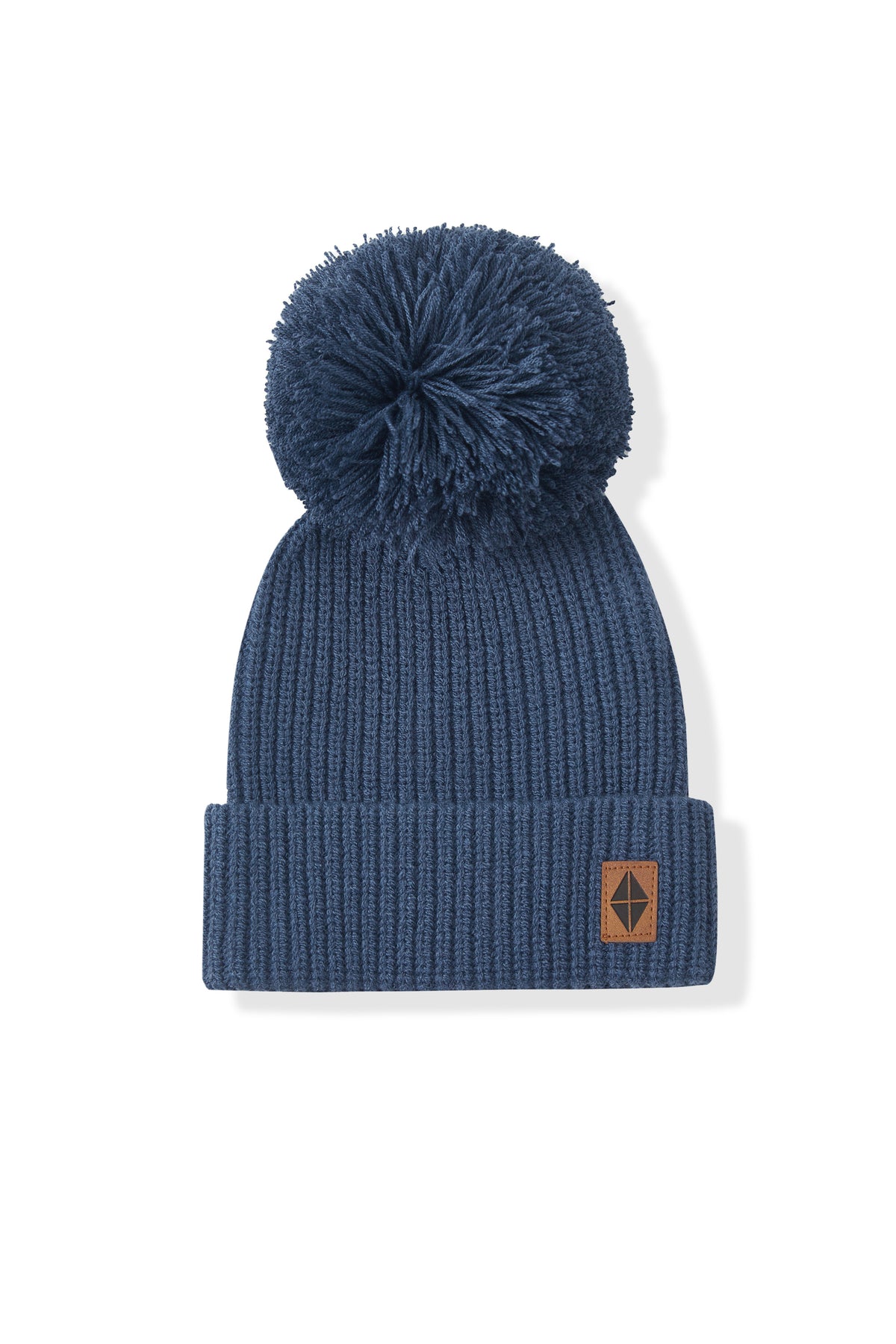 A navy blue ribbed knit pom-pom beanie hat with a small brown leather patch on the cuff, displayed against a clean white background.