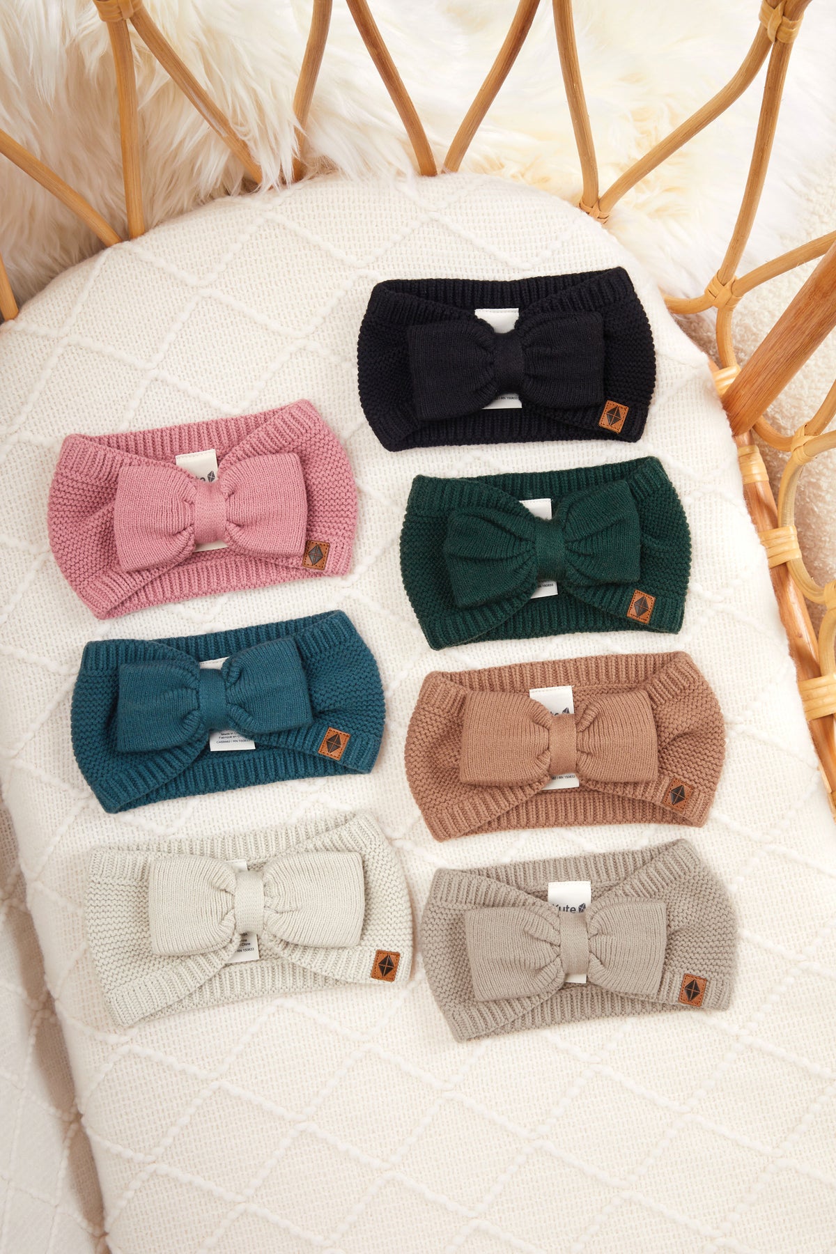 Chunky Knit Bow Headband in Apple Blossom, Oat, Almond, Latte, Cypress, Midnight and Pine lined in a crib