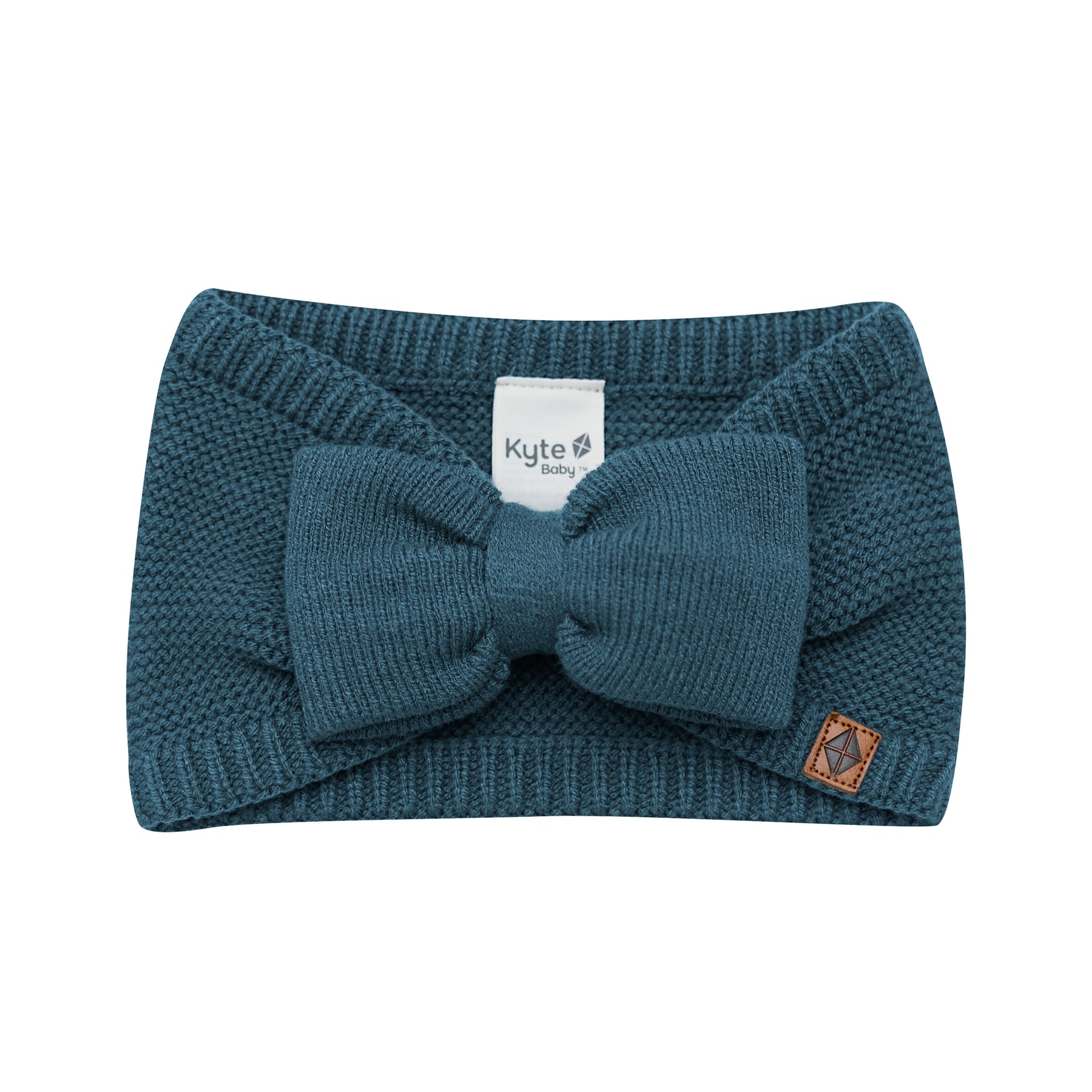 Product photo of the Chunky Knit Bow Headband in Atlantic with the Kyte Baby vegan leather tag visible