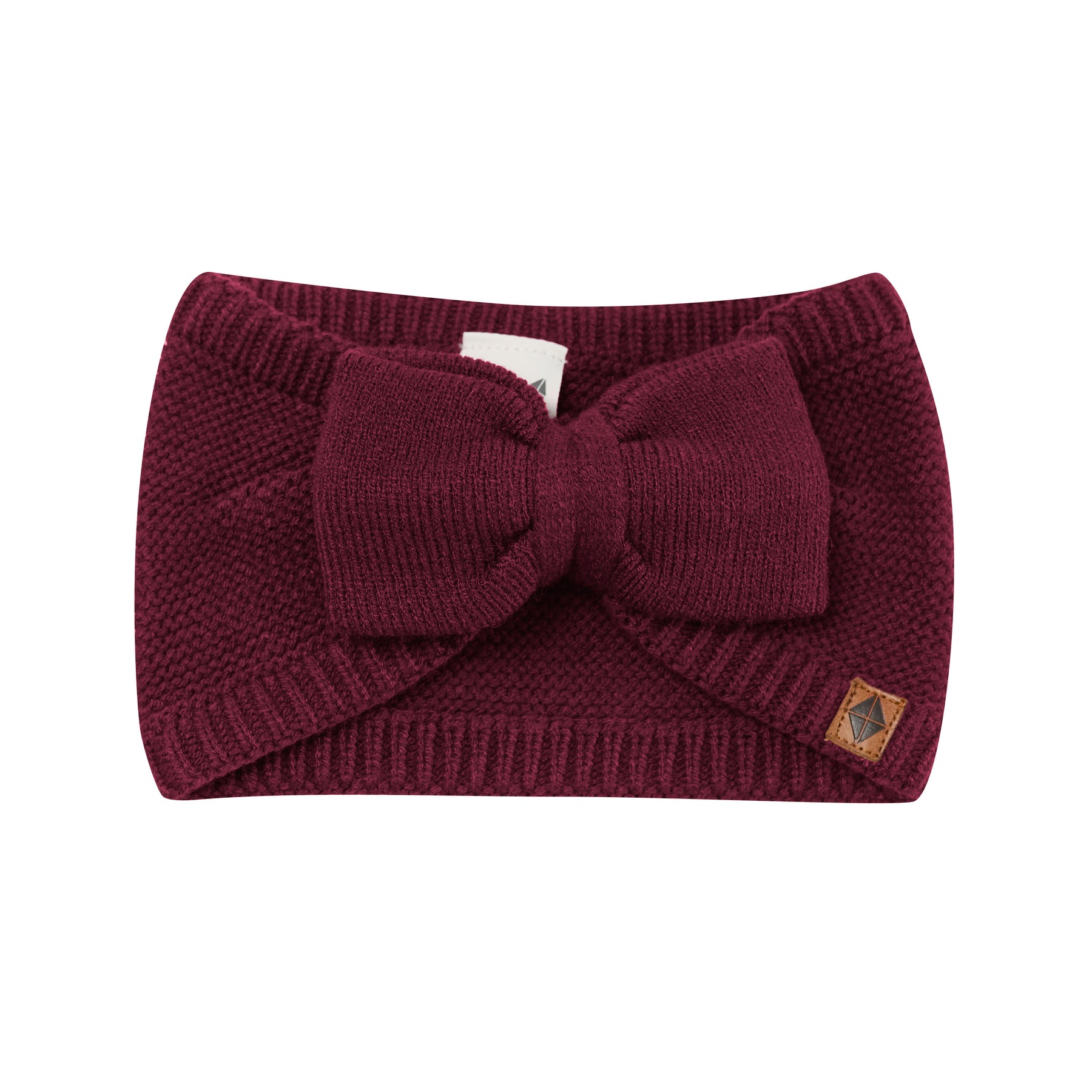 Product photo of the Chunky Knit Bow Headband in Burgundy with the Kyte Baby vegan leather tag visible