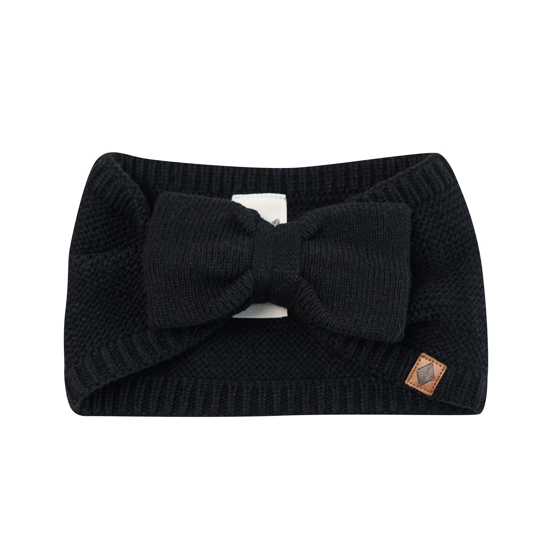 Product photo of the Chunky Knit Bow Headband in Midnight with the Kyte Baby vegan leather tag visible