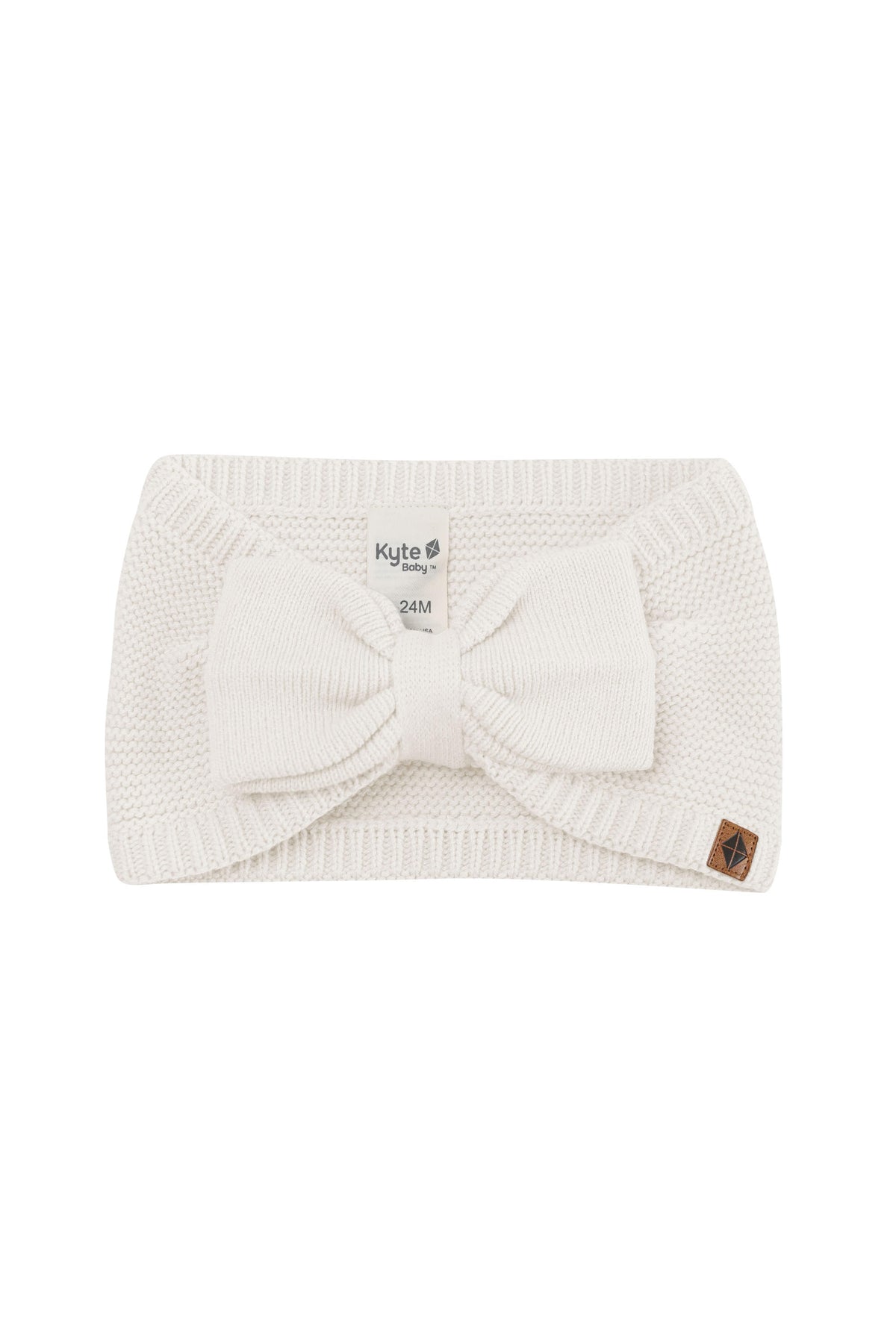 Product photo of the Chunky Knit Bow Headband in Oat with the Kyte Baby vegan leather tag visible